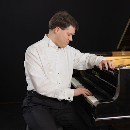 Pianist sitting on stage at the piano