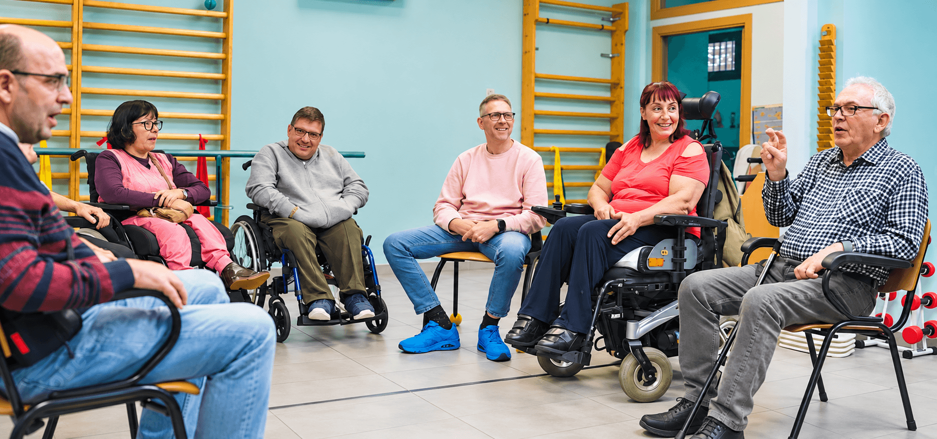 A group of disabled people and wheelchair users talking together in a community space.