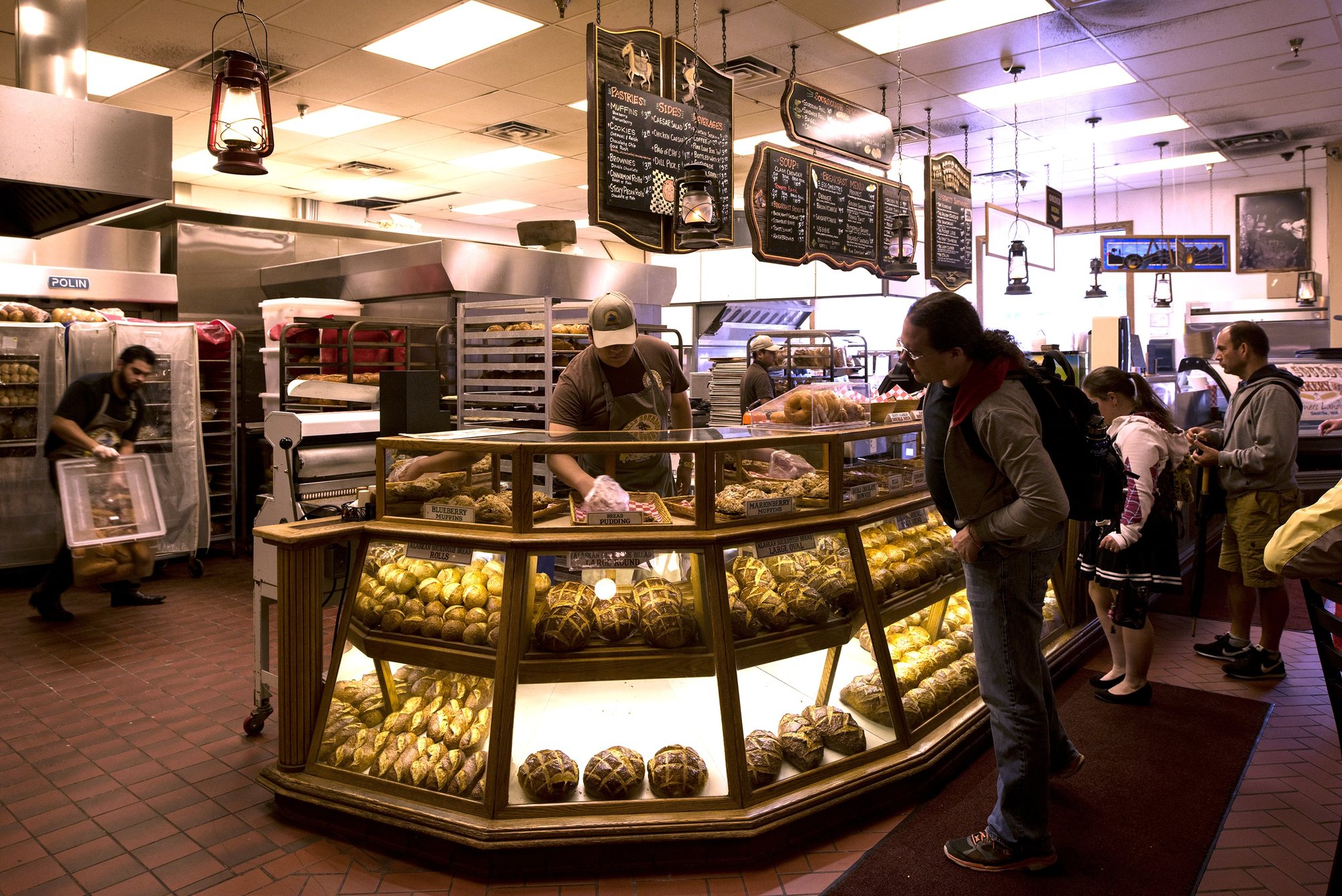 Guests at the lit bakery case under the lantern lights