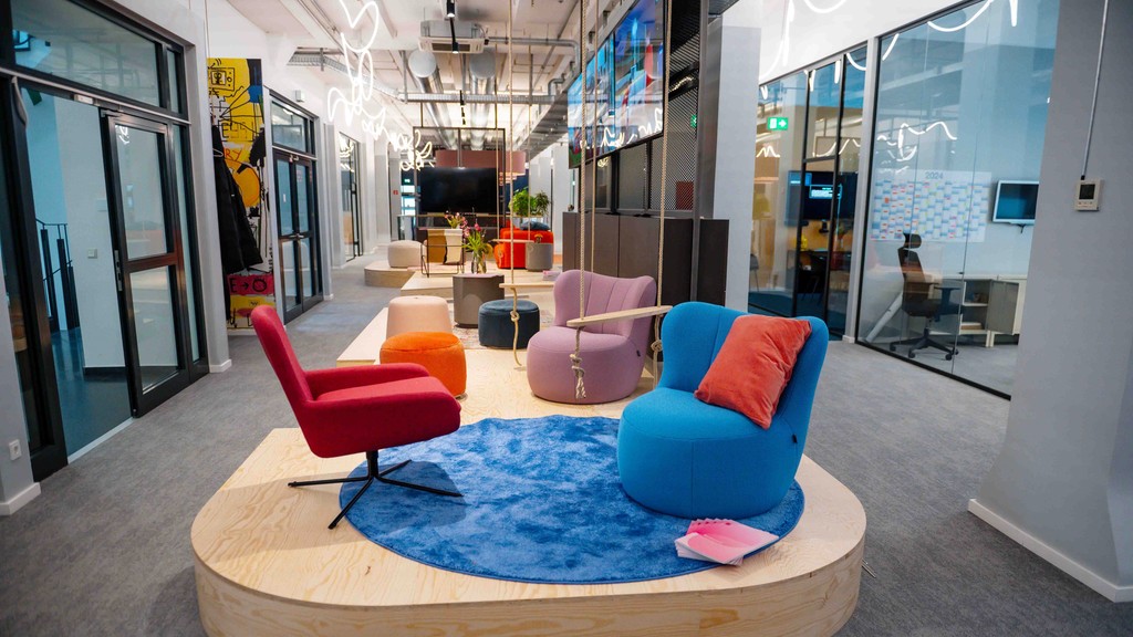 Colorful lounge chairs in a modern space, surrounded by light and contemporary decor.