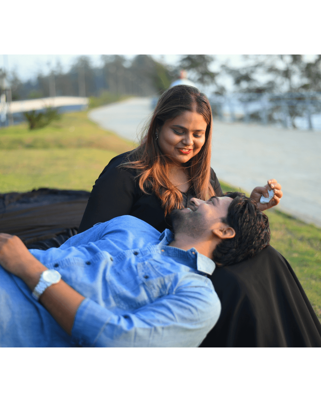 A couple embraces lovingly on a wooden dock.