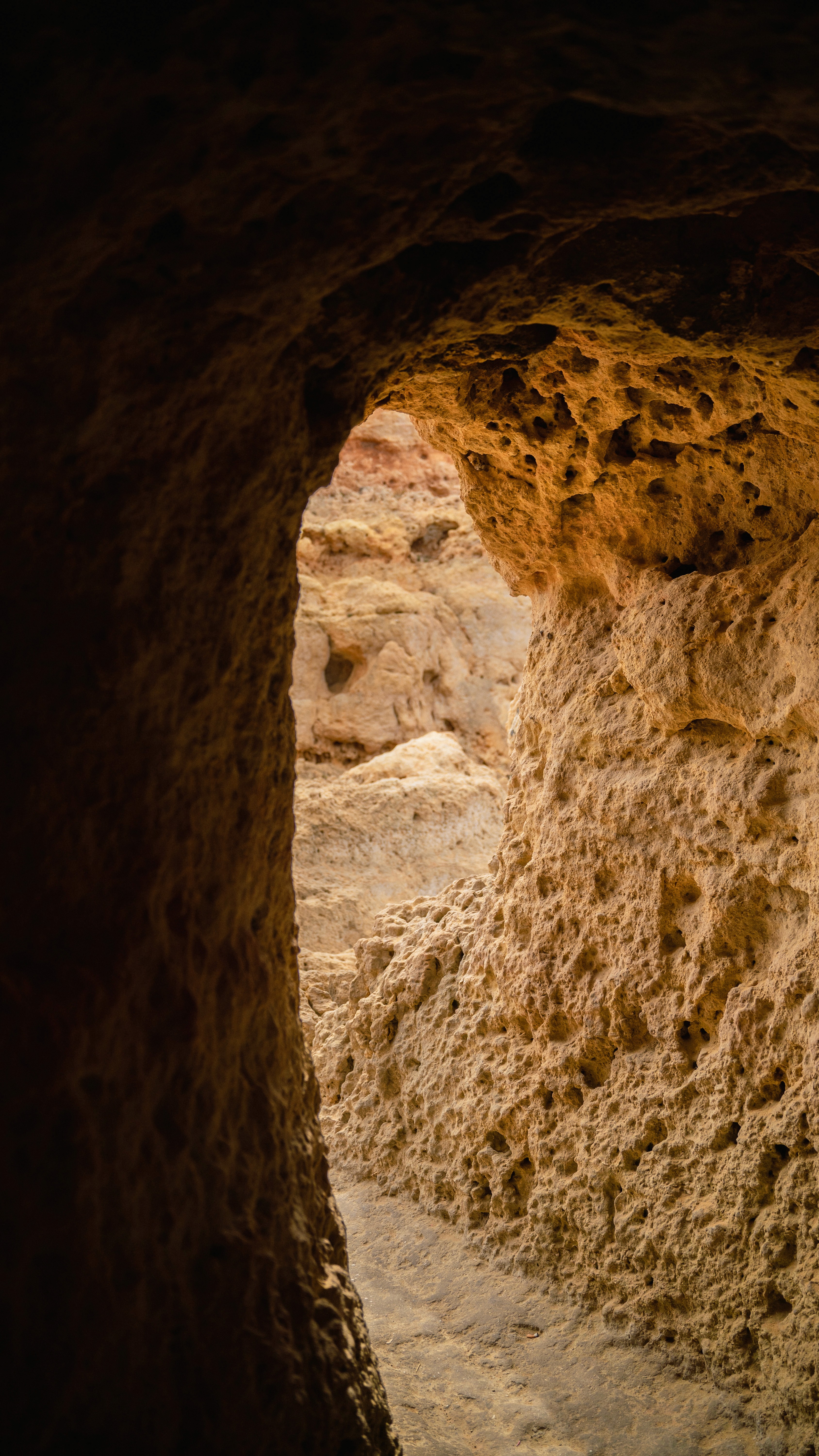 Durchgang im Sandstein einer Klippe, warmes Licht auf dem Fels