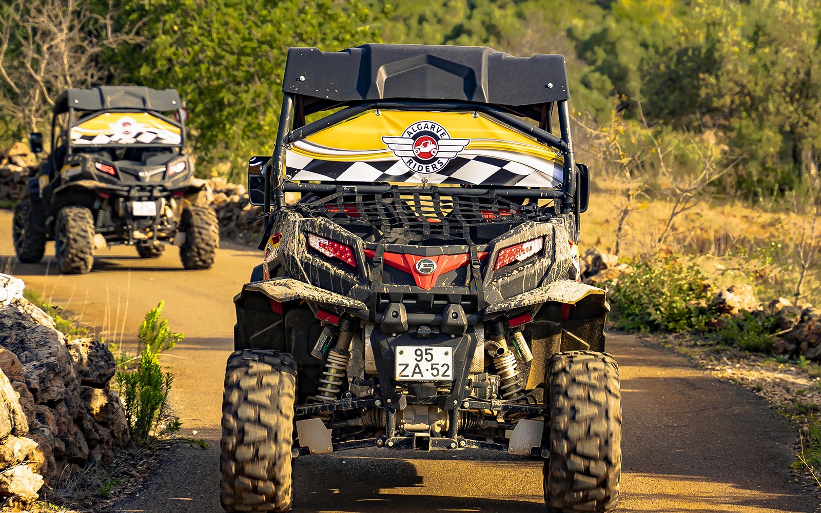 Buggy driving on a dirt path during Algarve tour, surrounded by greenery.