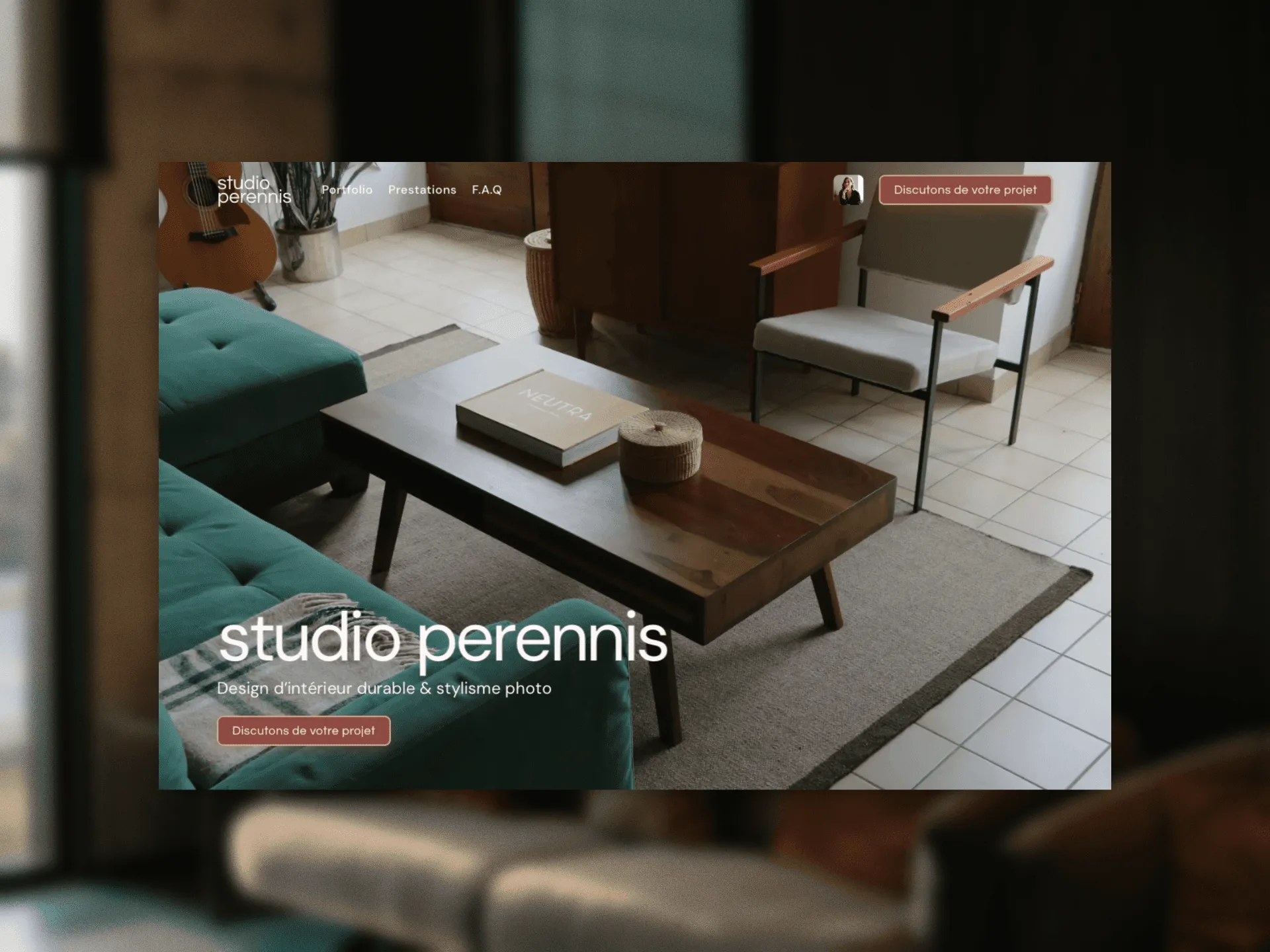 Studio Perennis interior design website mockup showing a warm living room with a teal sofa, guitar, coffee table, and project navigation.