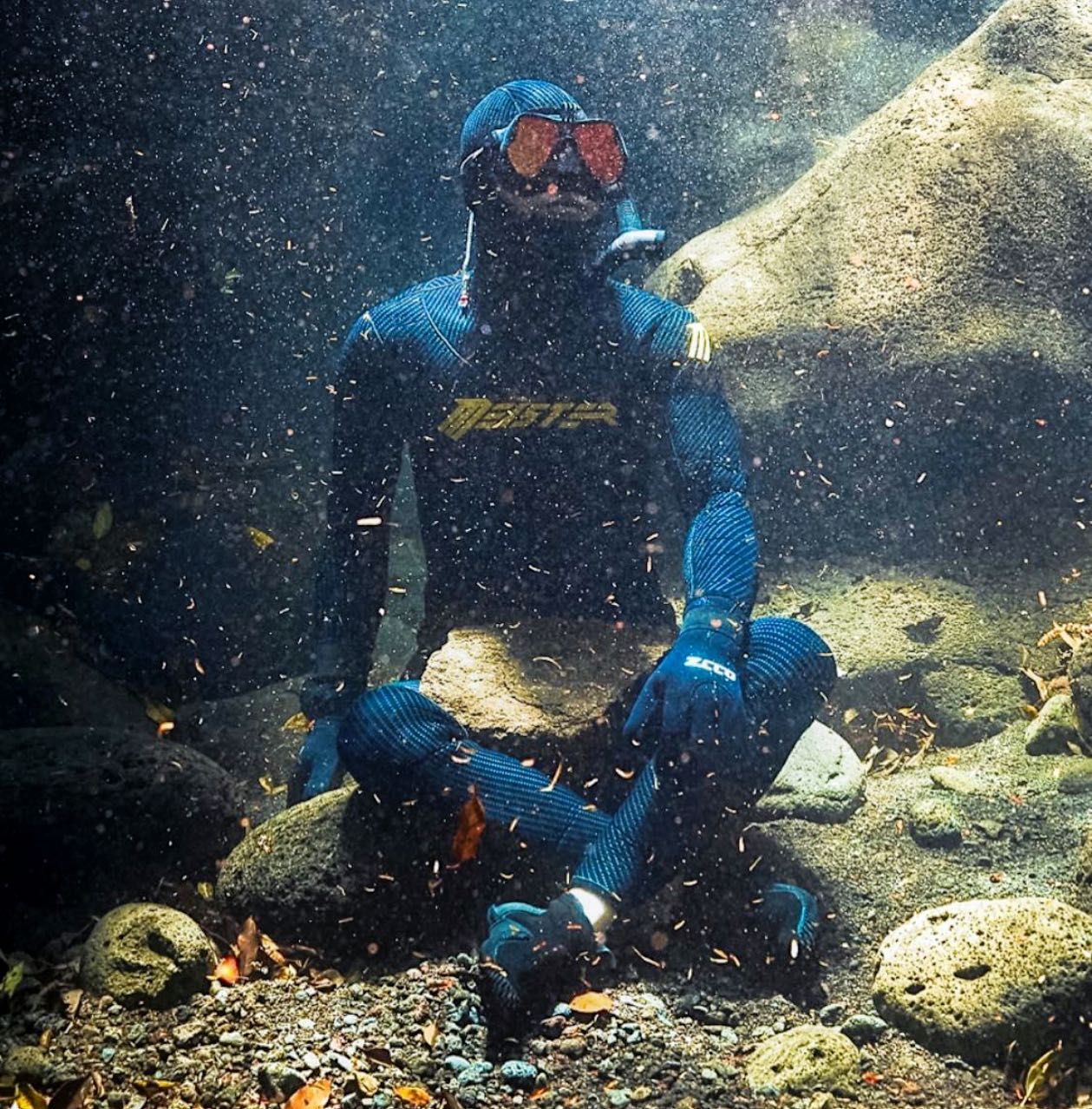 freediver meister sitting on a rock underwater