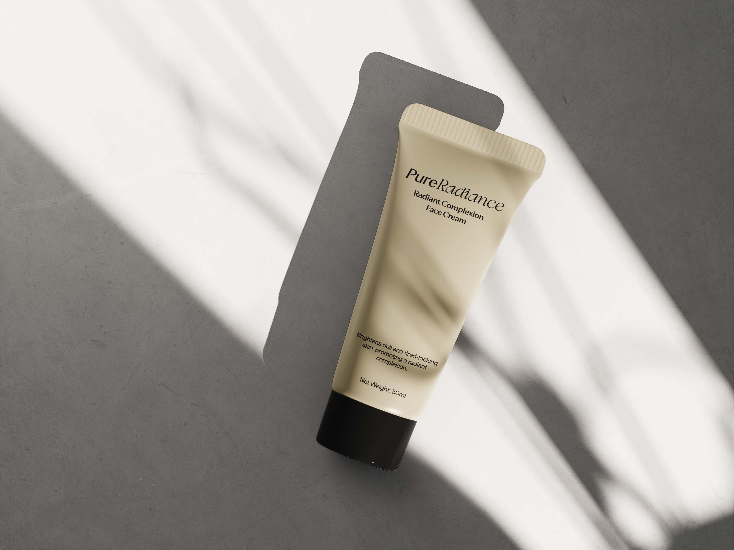 A tube of cream rests on a gray surface, illuminated by soft natural light casting a shadow beside it.