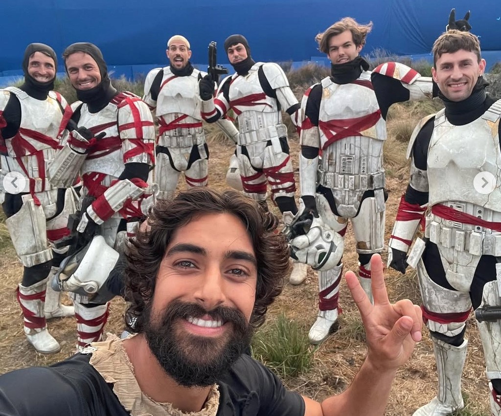 Eman Esfandi giving a peace sign in front of stormtrooper extras without their helmets on