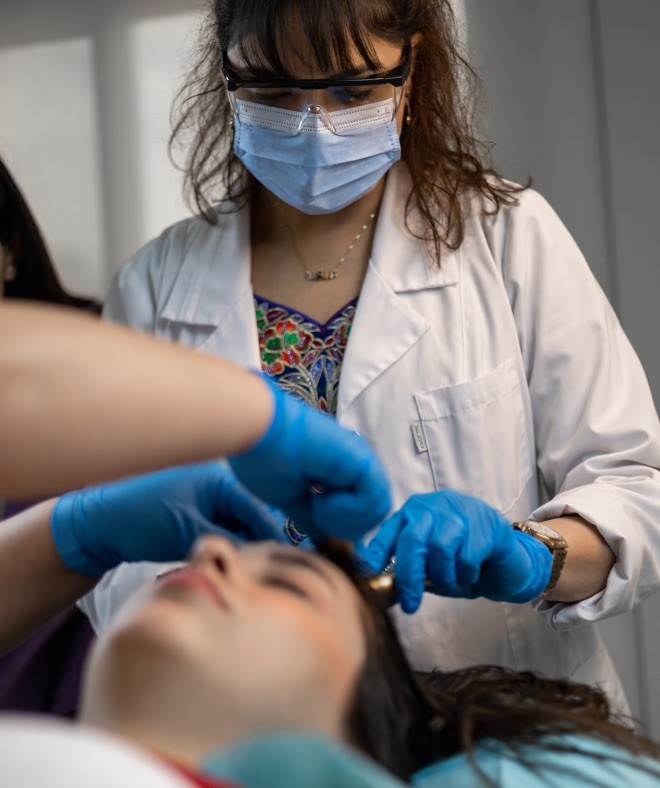 Doctor performing hair loss treatment on patient.