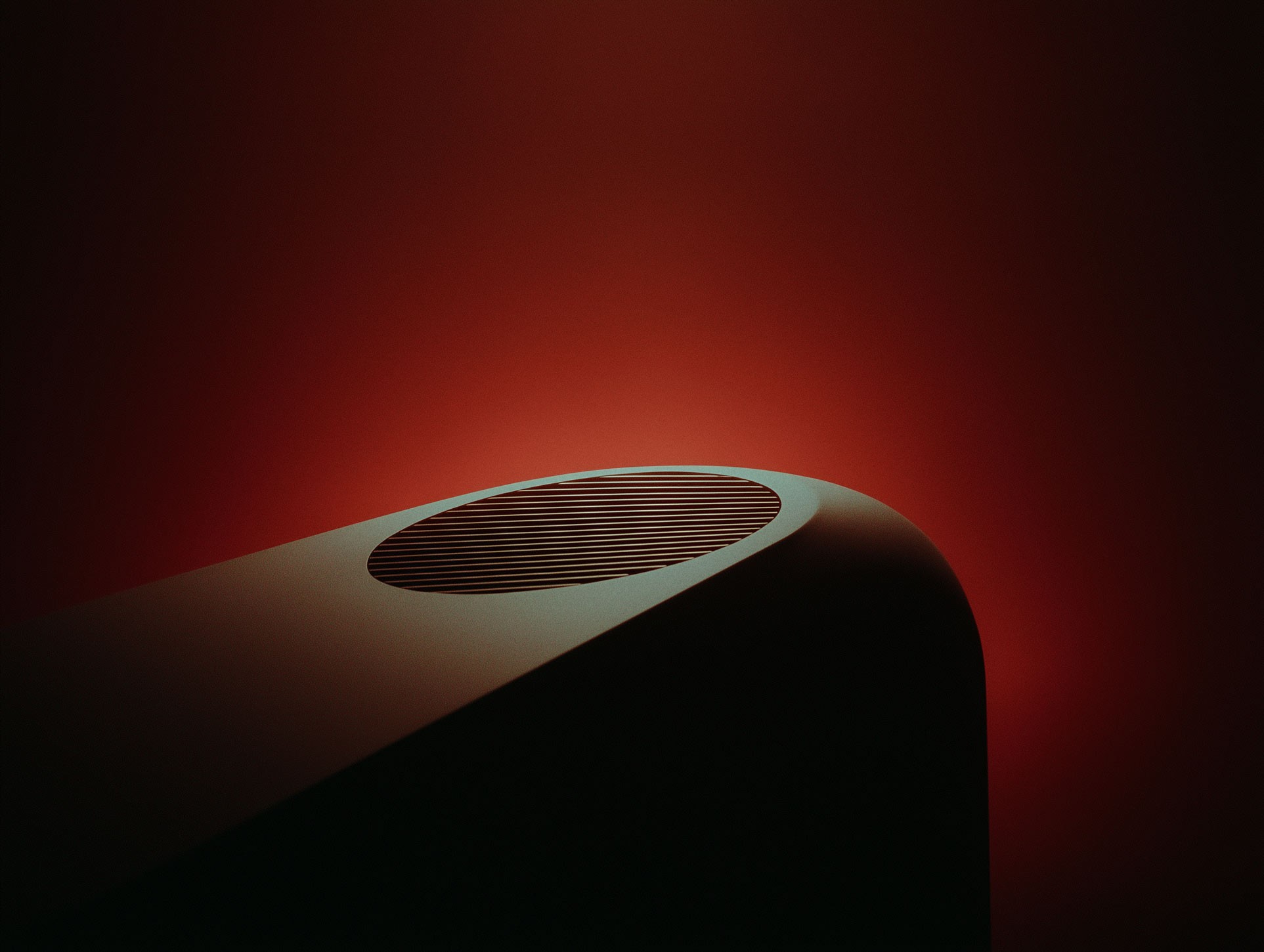 Sculptural curved furniture piece in deep red room