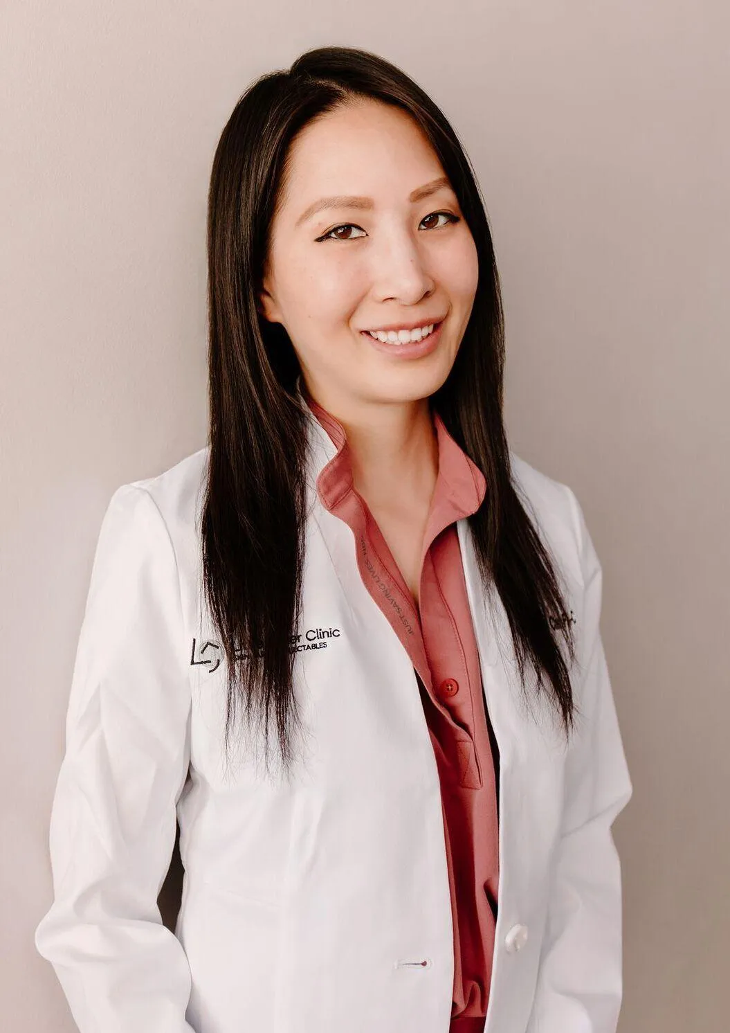 Forever Booked results partner Christine Chen, owner of Little Laser Clinic, in professional lab coat headshot