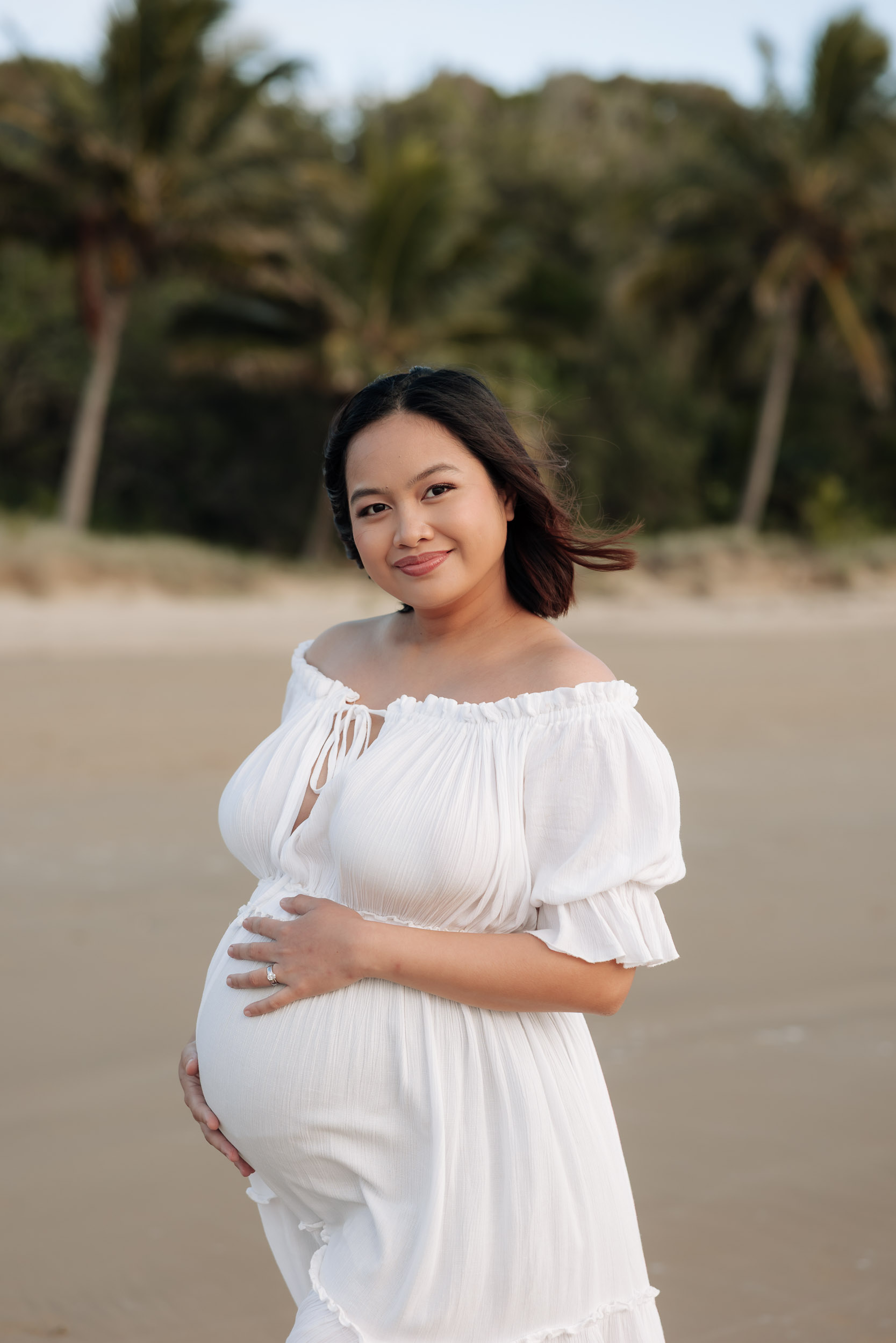 Close up of pregnant woman in front of palm trees