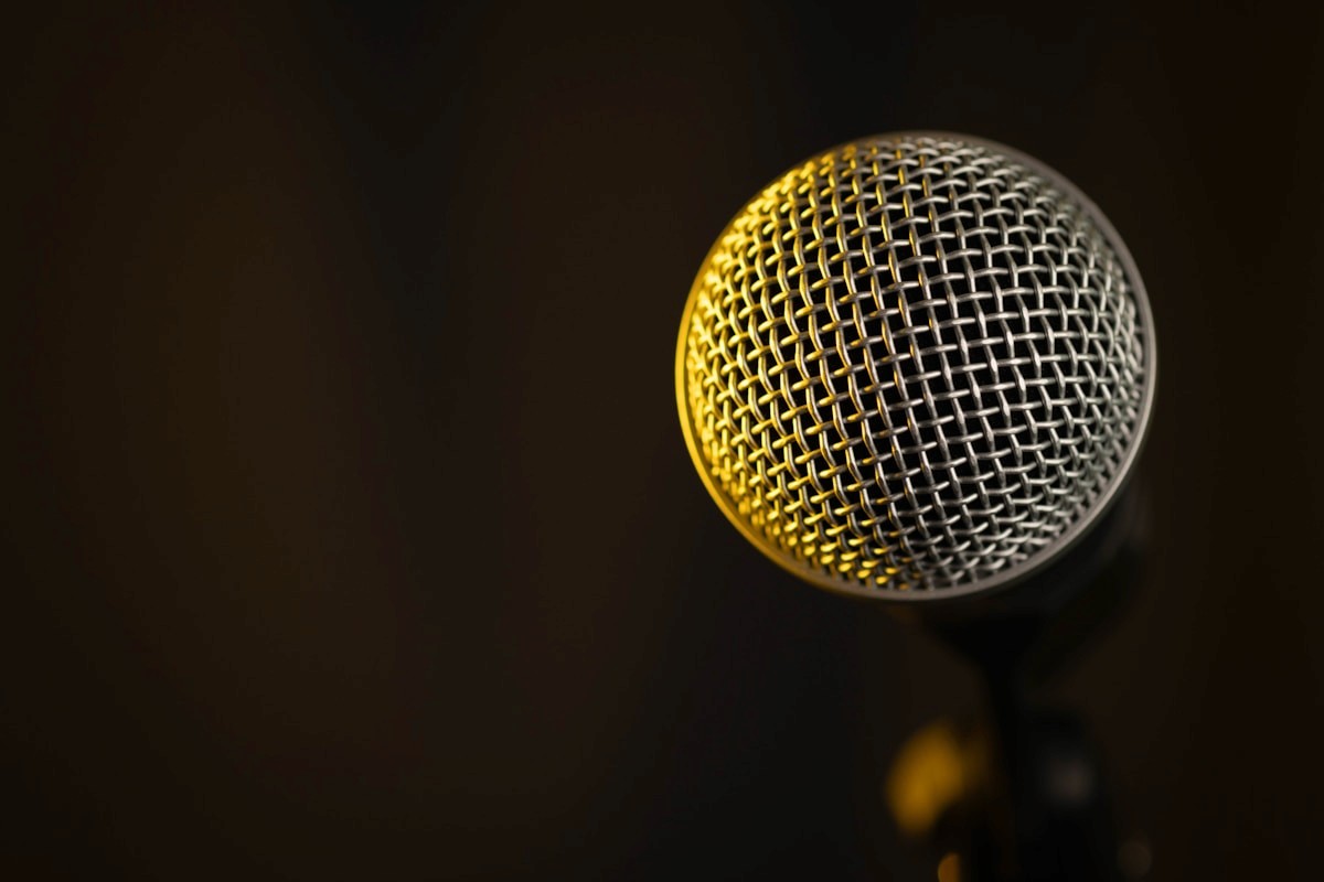A broadcast microphone caught in warm amber light