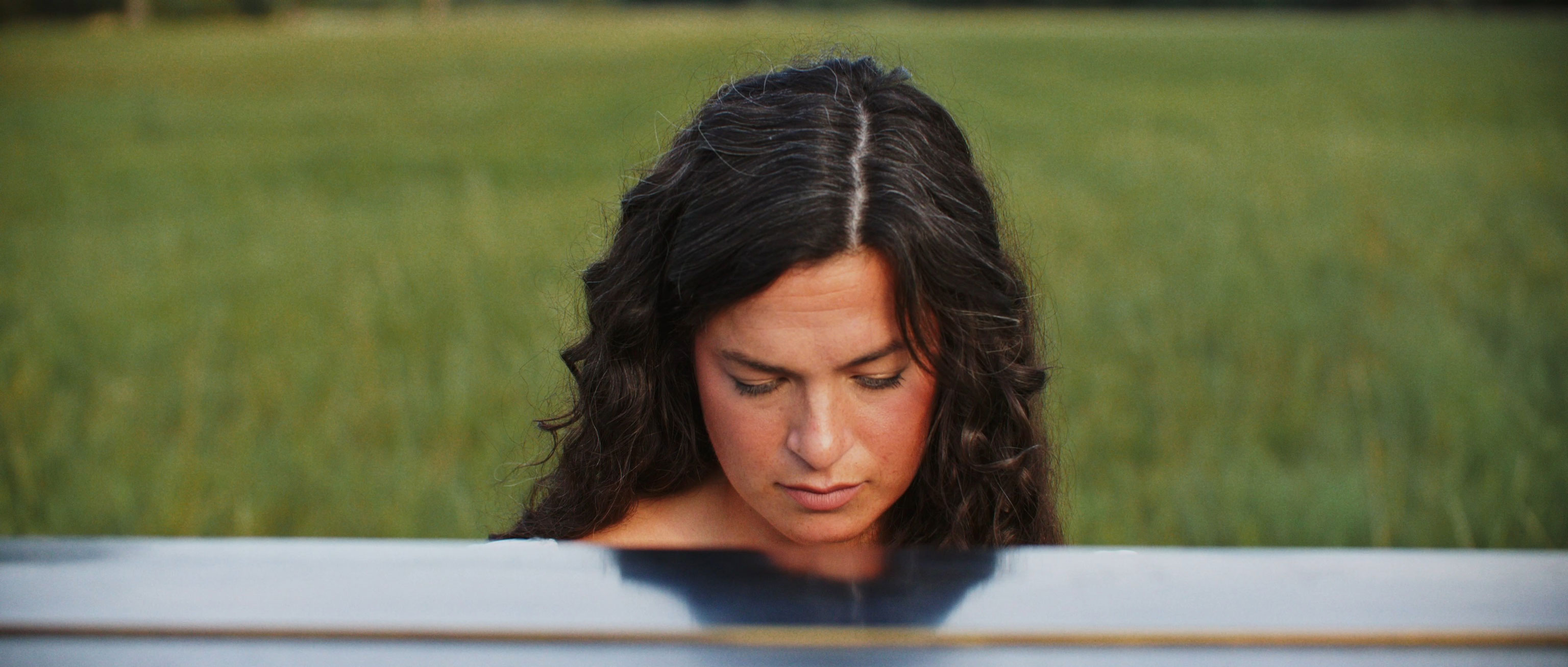 a woman sits at a piano