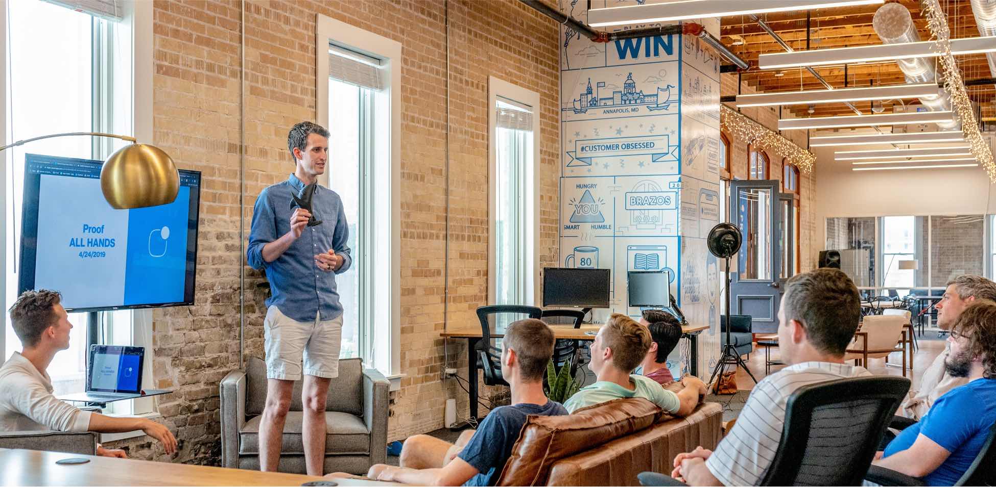 People at a podium talking to people in an indoor setting.