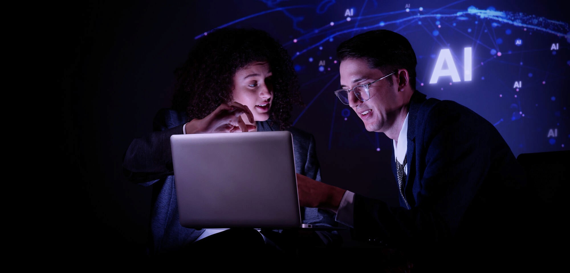 A woman with red hair and a black sleeveless top smiling confidently in a bright, modern indoor setting.