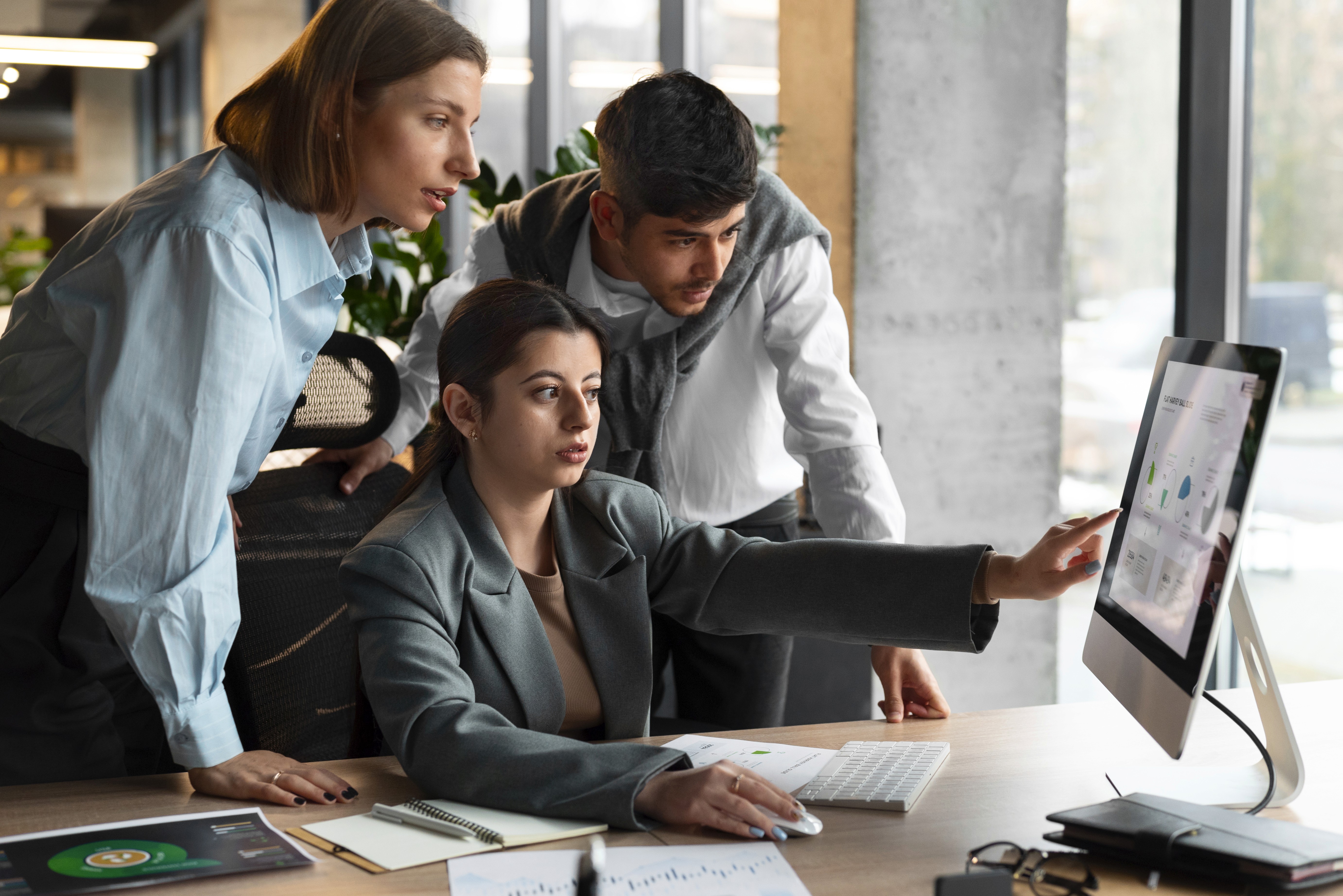 3 workers looking at a monitor screen