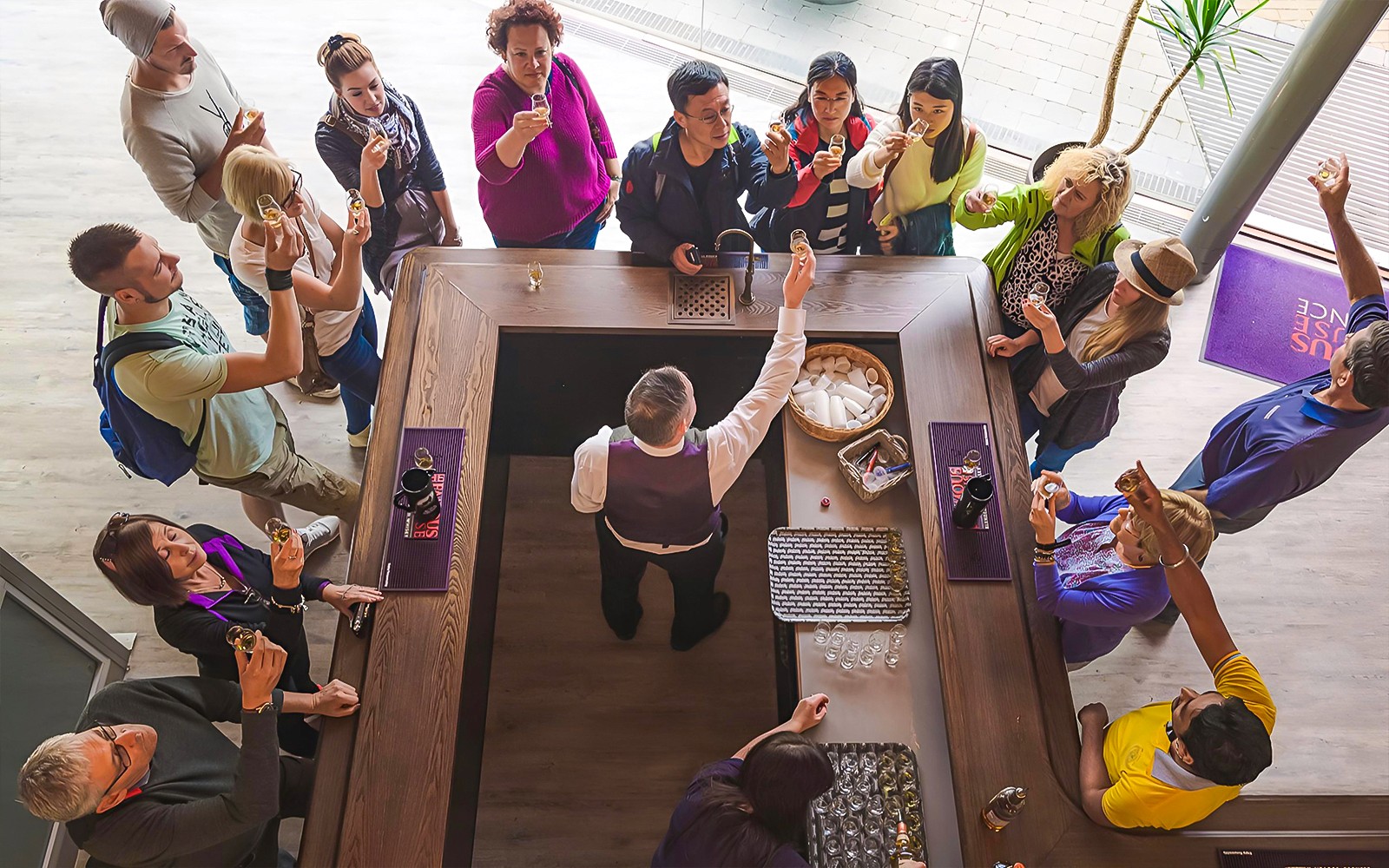 Tour group tasting whisky at a distillery bar in Edinburgh.