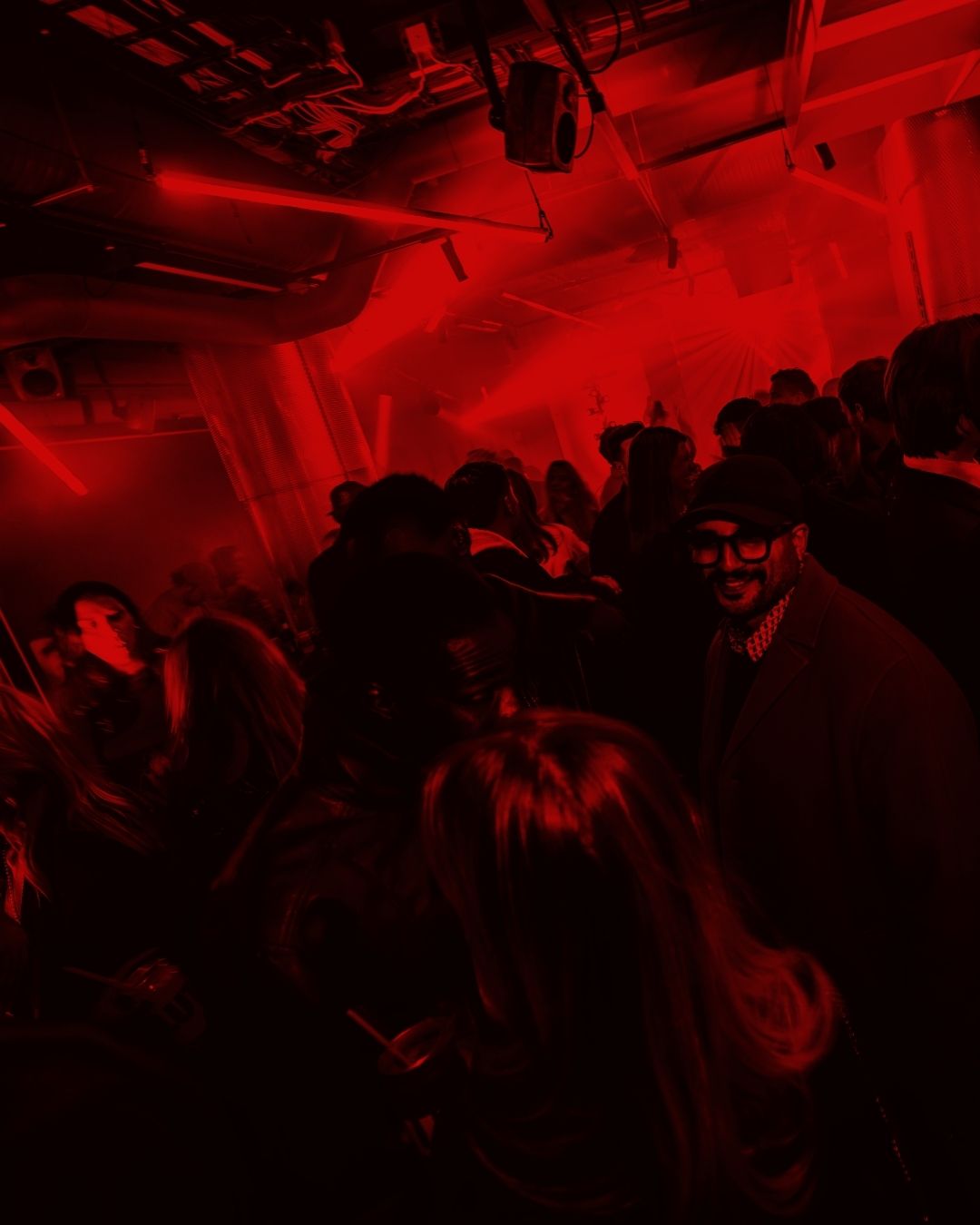 Iced coffee in a clear plastic cup with Orbit logo and swirling milk over a neutral background