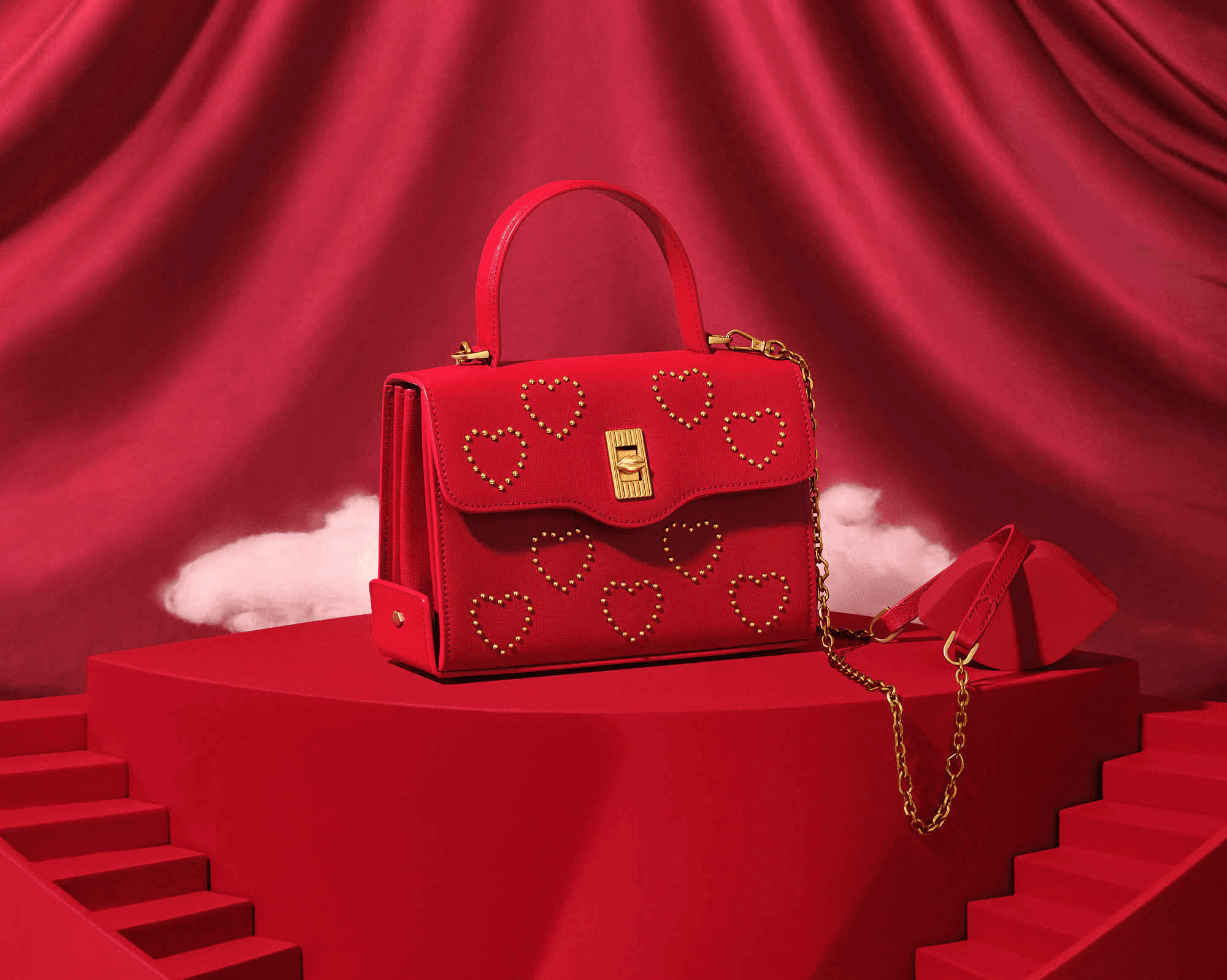 Red handbag with gold heart studs on elegant red background.
