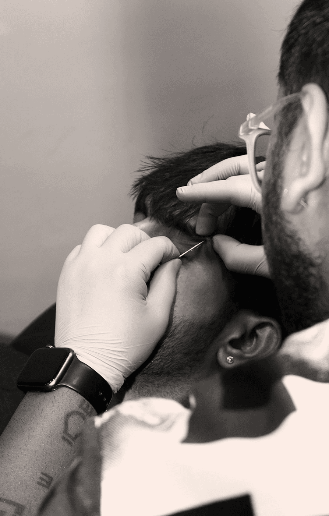 A man with long hair is working on a computer.