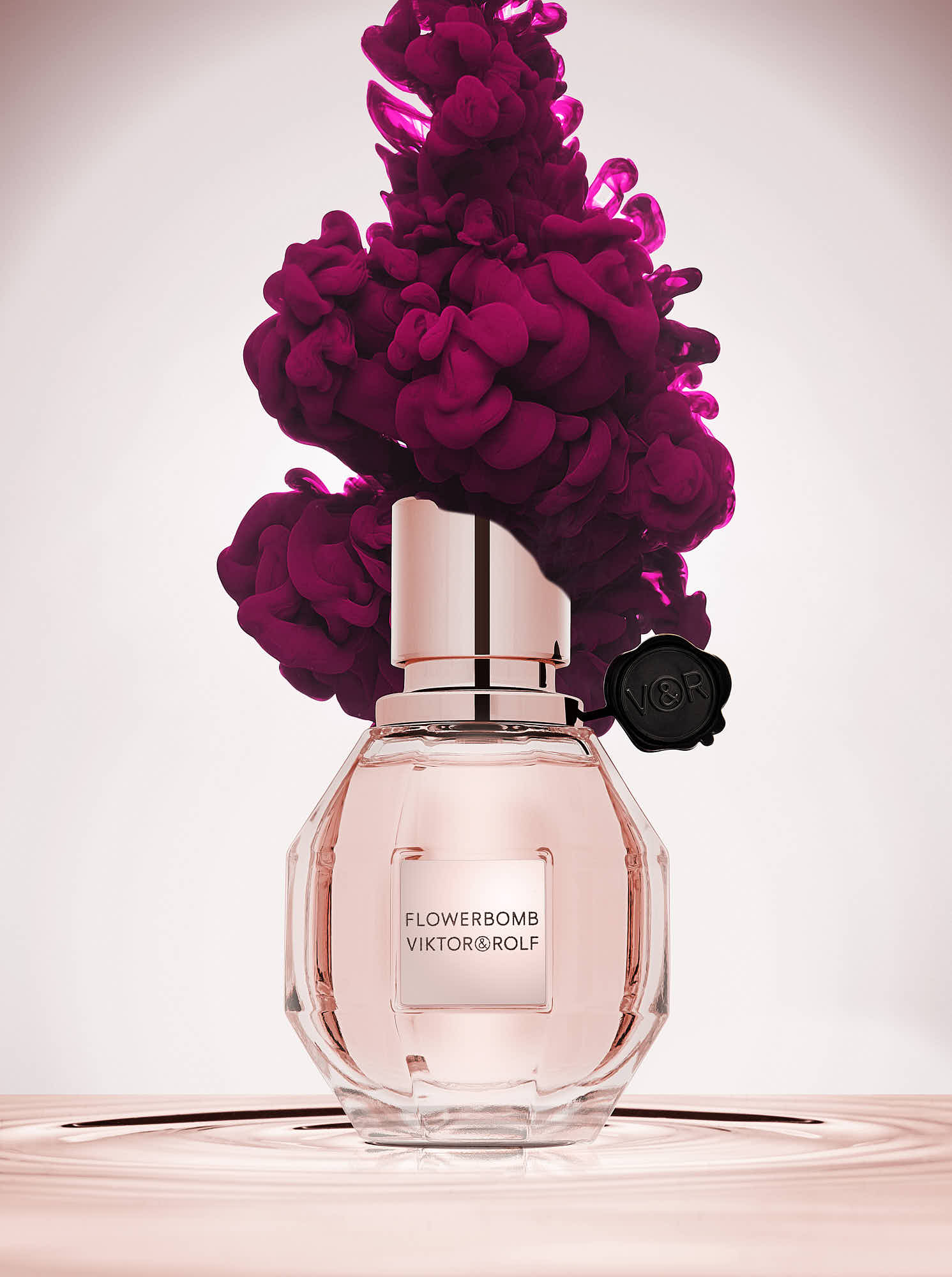 Viktor & Rolf Flowerbomb perfume bottle with vibrant pink ink cloud.