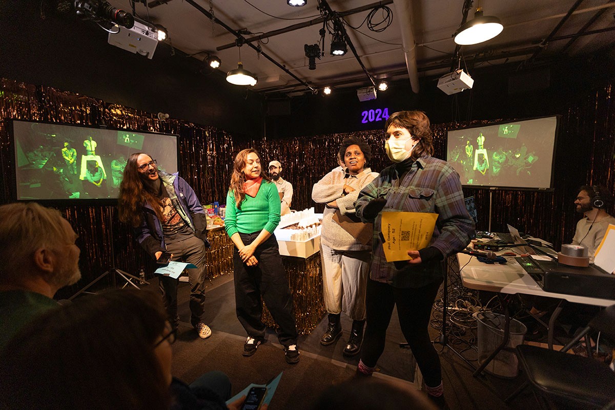 Three audience members stand on stage to run for mayor.
