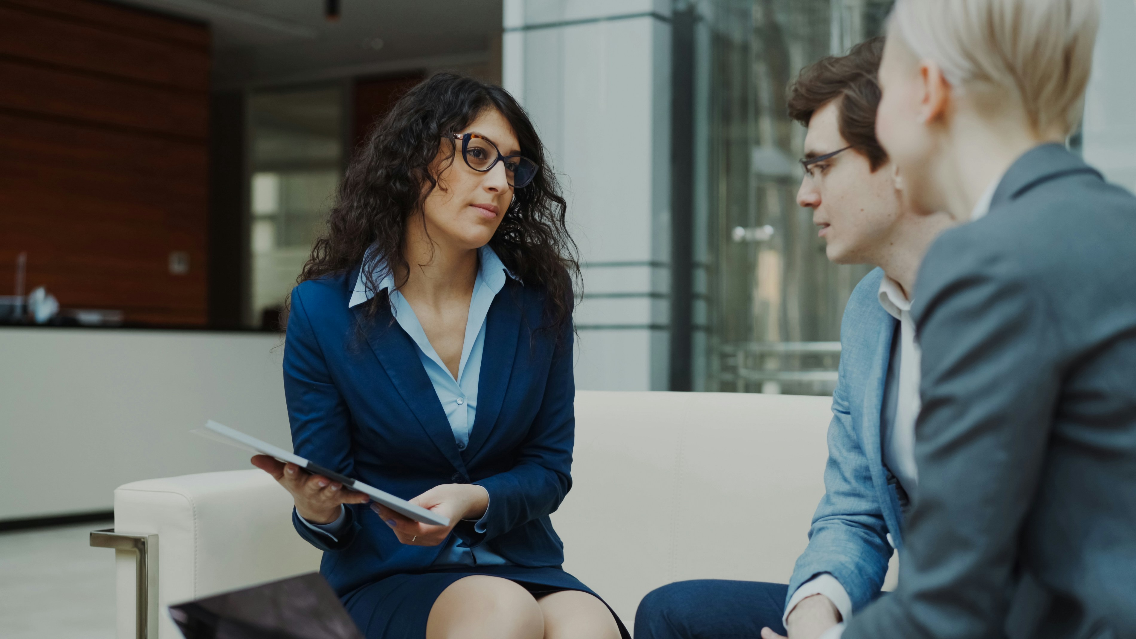 Three professionals in a business meeting discussion