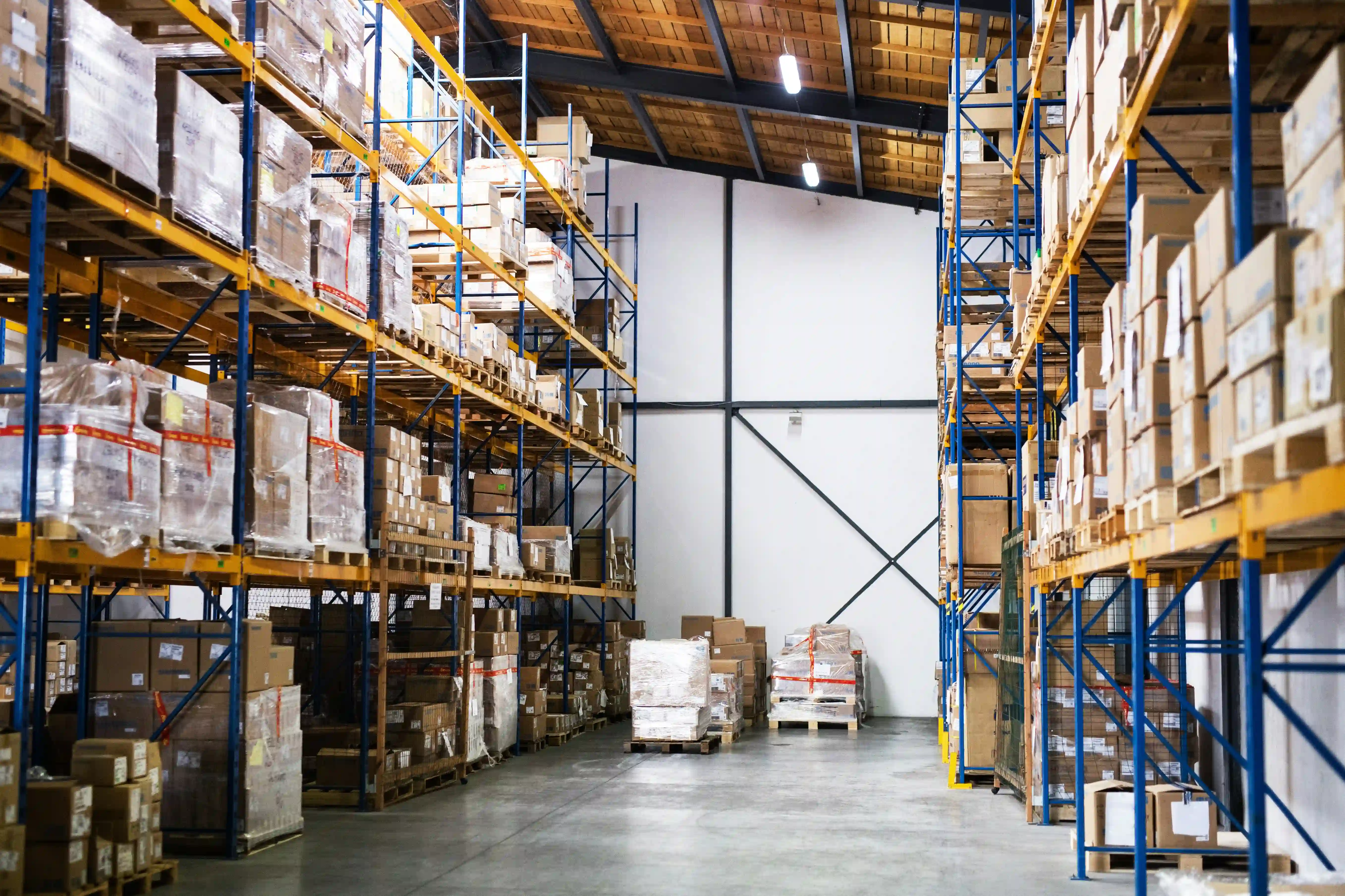 inside of a busy 3PL warehouse full of boxes and bright blue and yellow racking