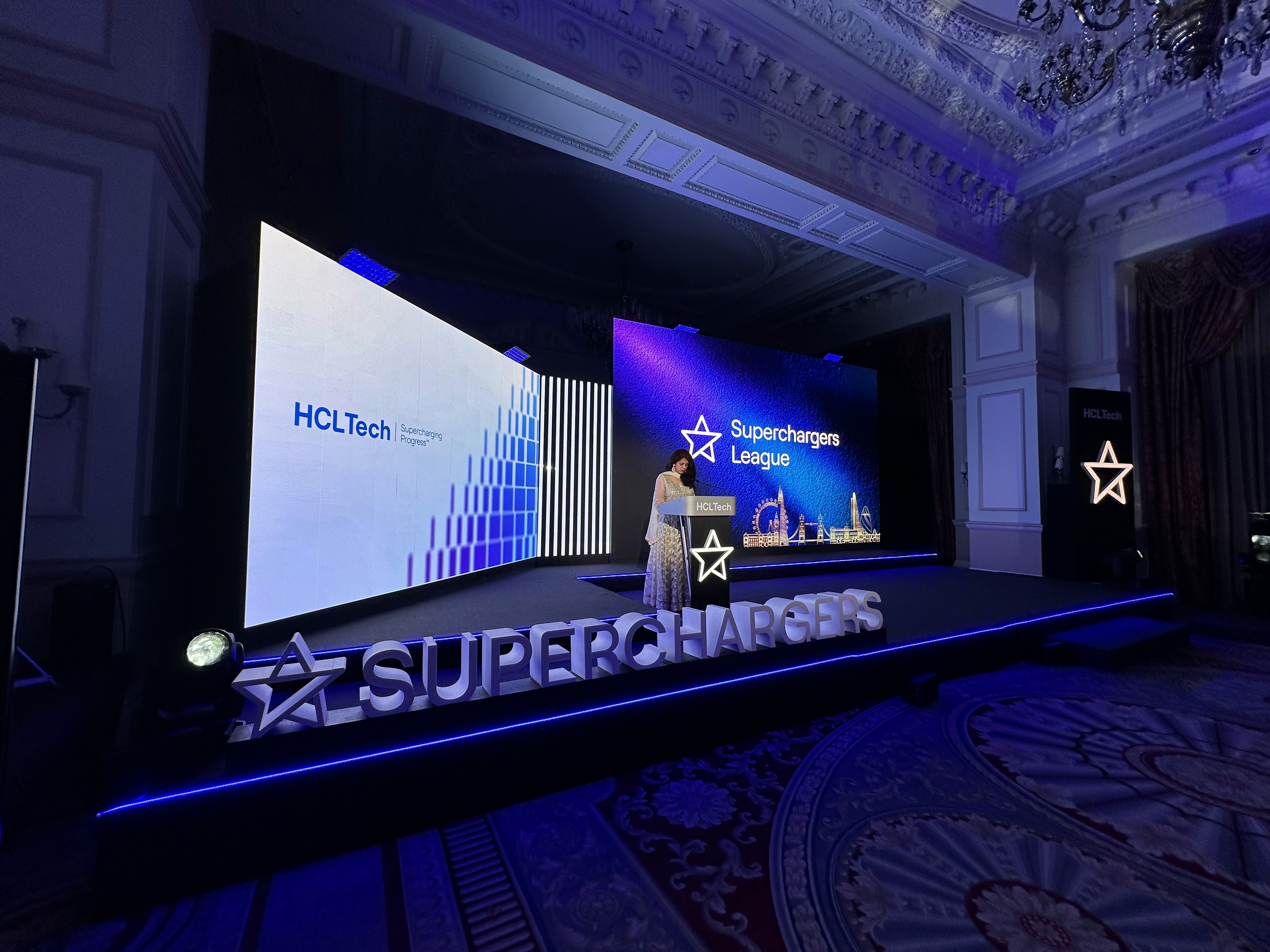 HCLTech Superchargers Awards stage with large LED screens, an illuminated lectern and scenic lettering at The Landmark London.