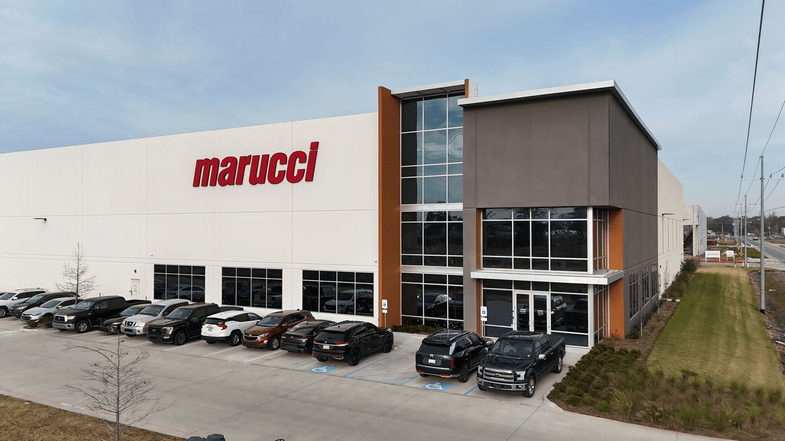 Front corner view of the Rivermark Phase I warehouse with Marucci signage and employee parking.