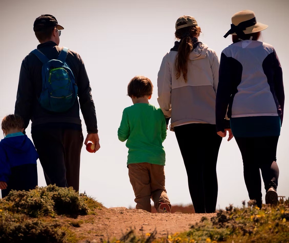 Adults and a child walking on a nature trail