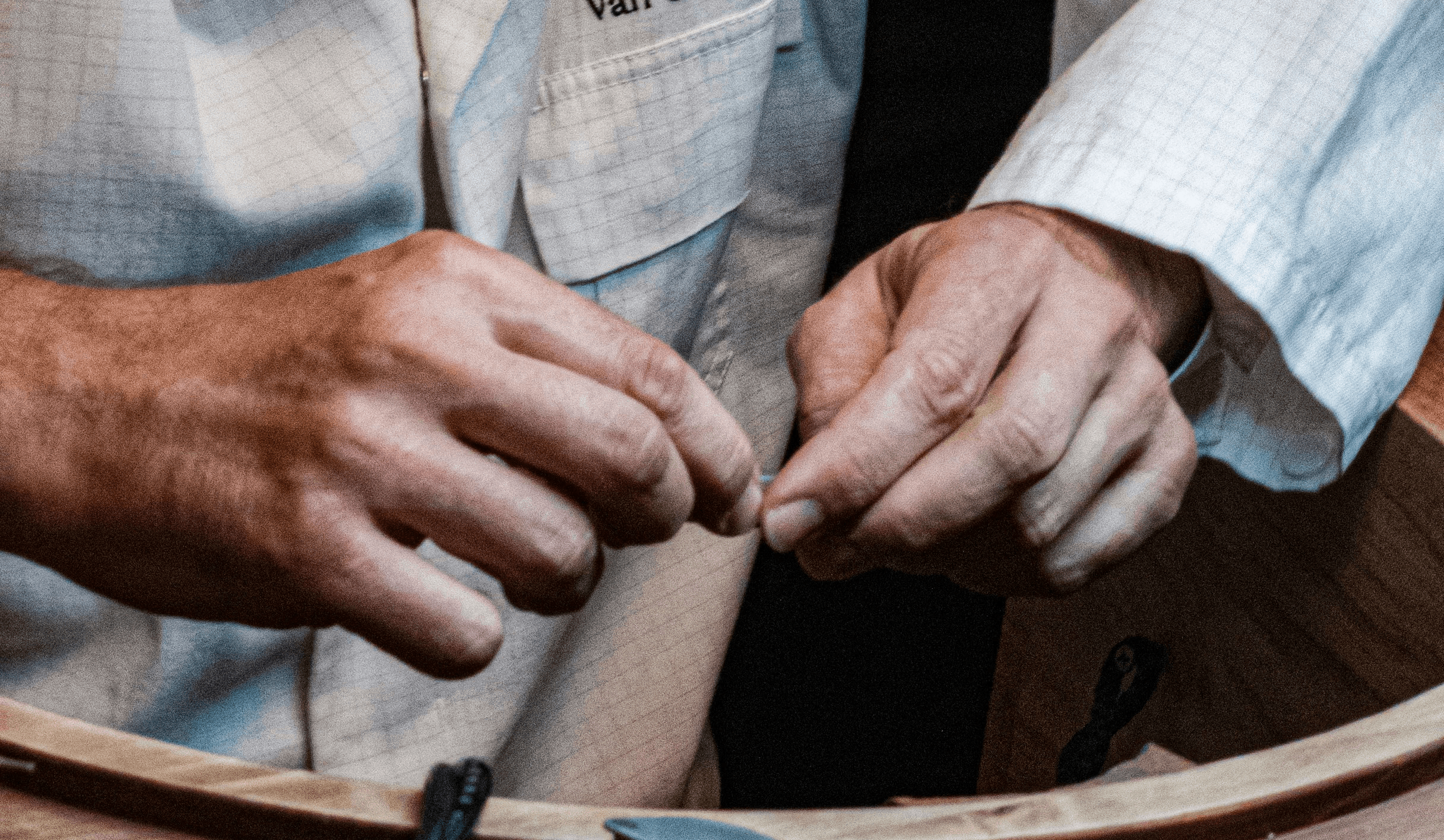 a man in a white shirt and a mask working on a piece of wood