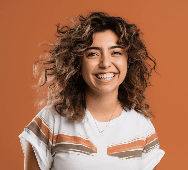 A young woman with curly hair smiles brightly in this portrait.