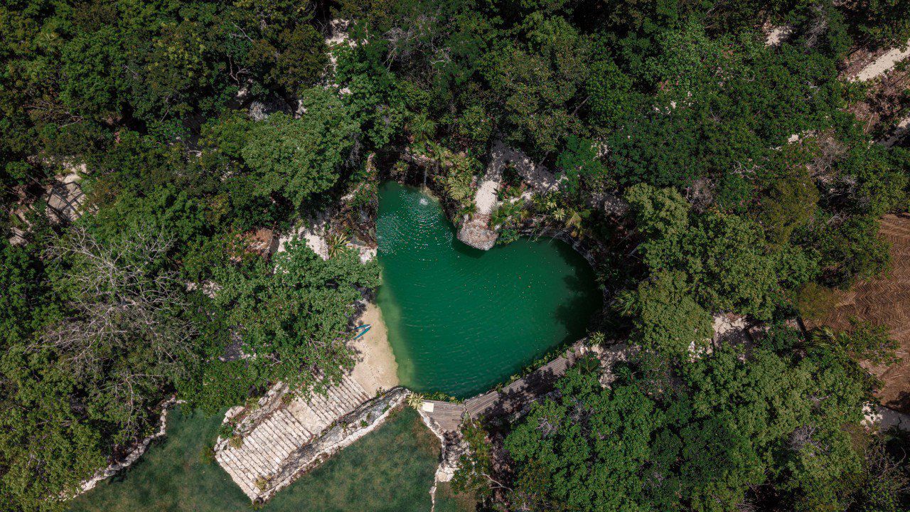 Stone kitchen with cabinets, exposed beam ceiling, terracotta floors.