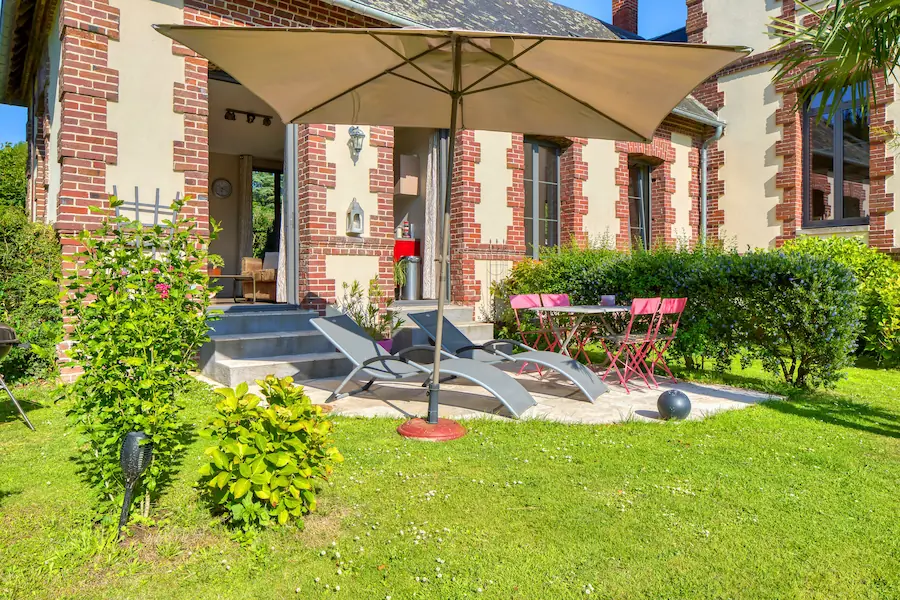 Terrasse ensoleillée du cottage Veules-les-Roses en Normandie avec transats et jardin