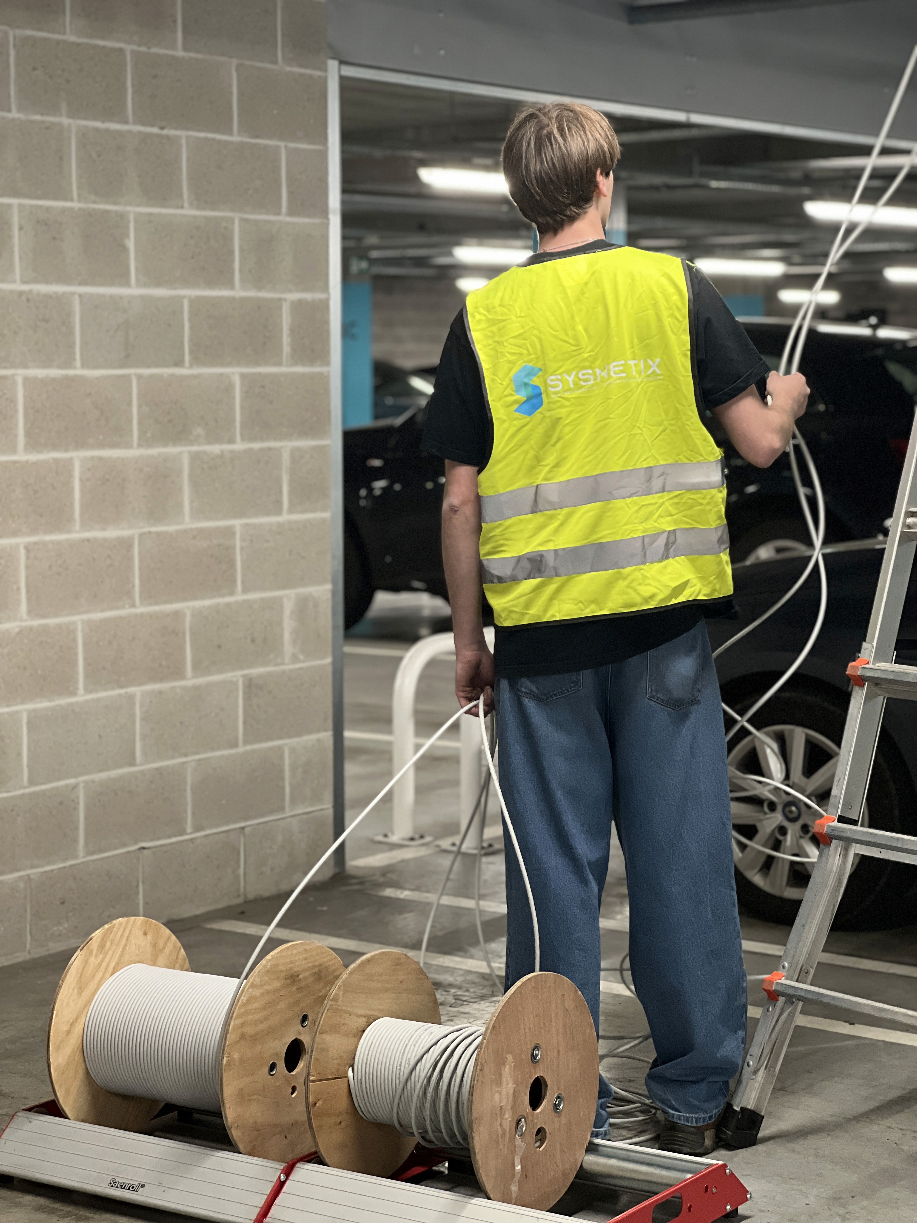 Technicus met kabelrollen tijdens de bekabeling van de parkeergarage