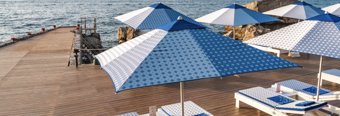 Blue parasols at Cava Regia beach club, Sorrento Coast
