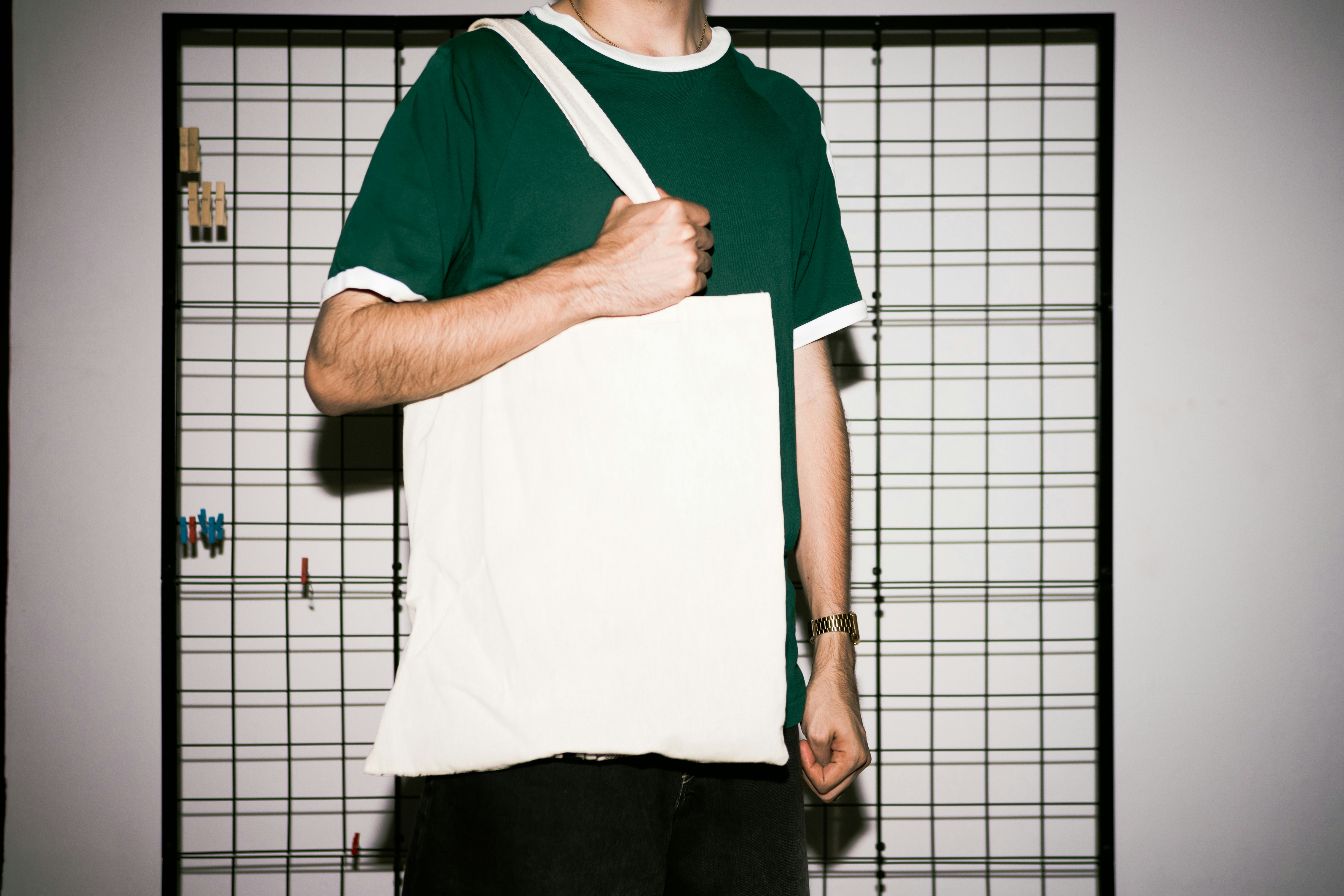 homme tenant un tote bag vierge destiné au merchandising