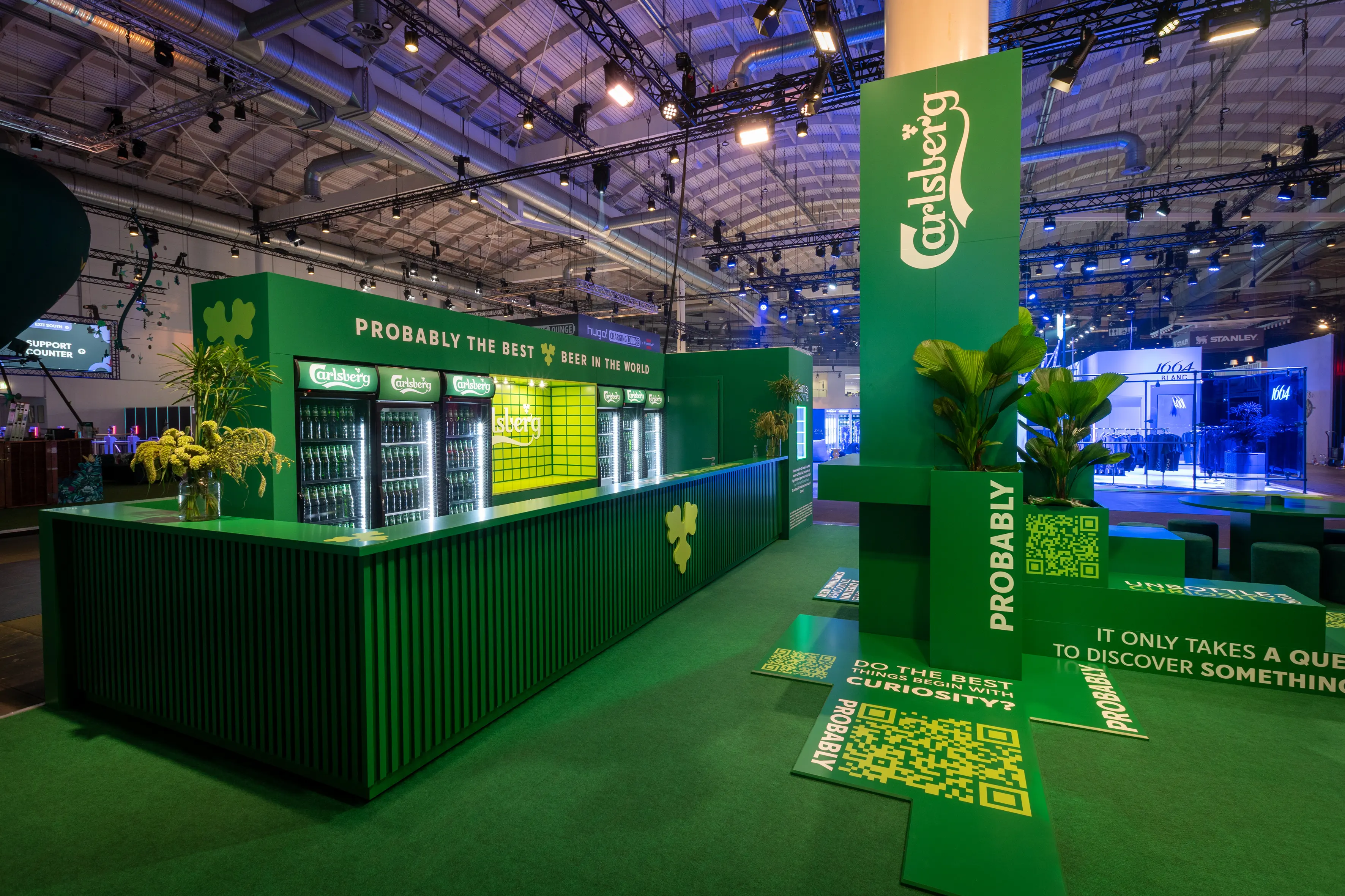 Carlsberg booth at OMR all in green with container bar, logo pillar and walk-on QR codes on the floor.