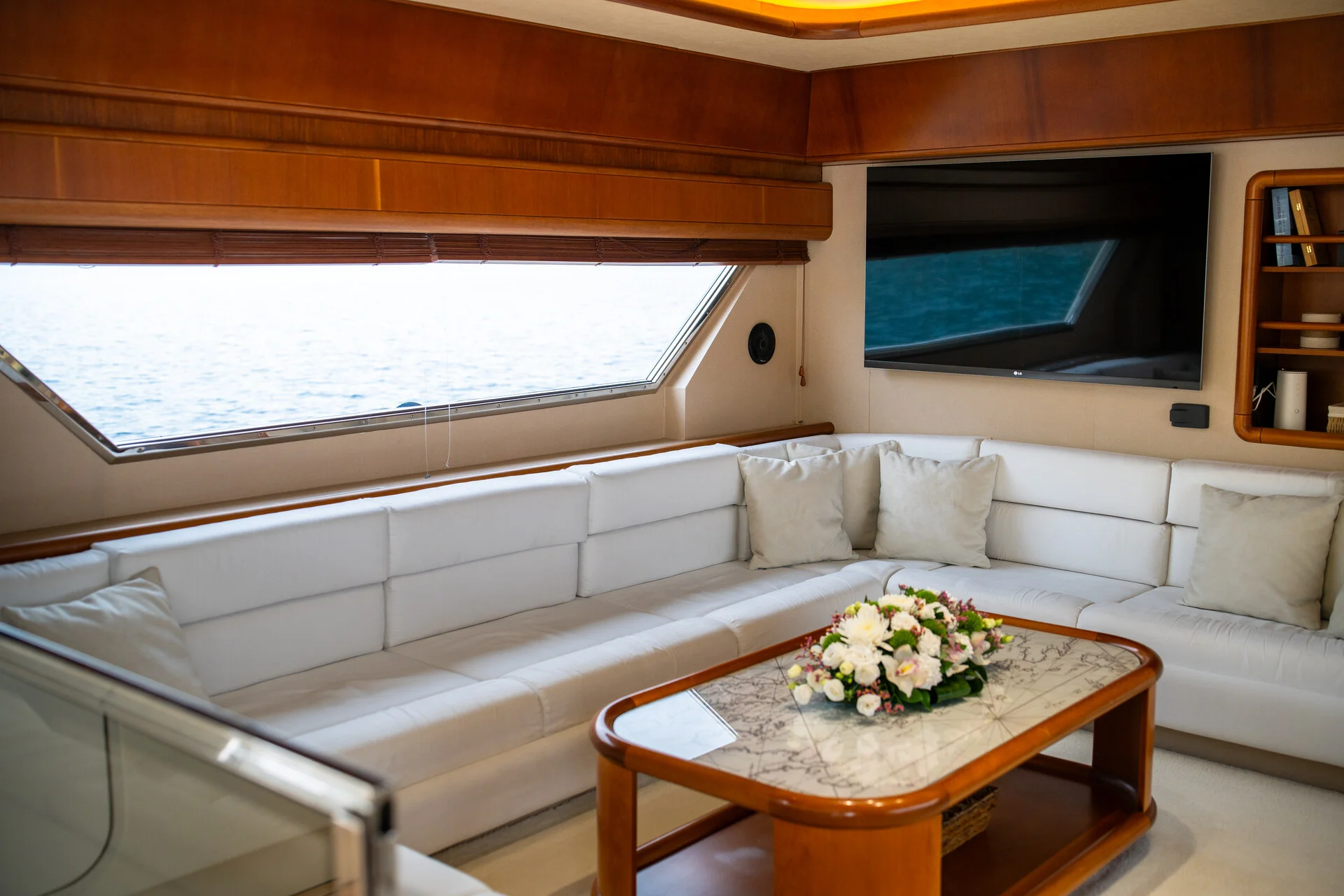 White Rock 36 speedboat with captain at helm cruising calm blue waters near Paros coastline with hills in background.
