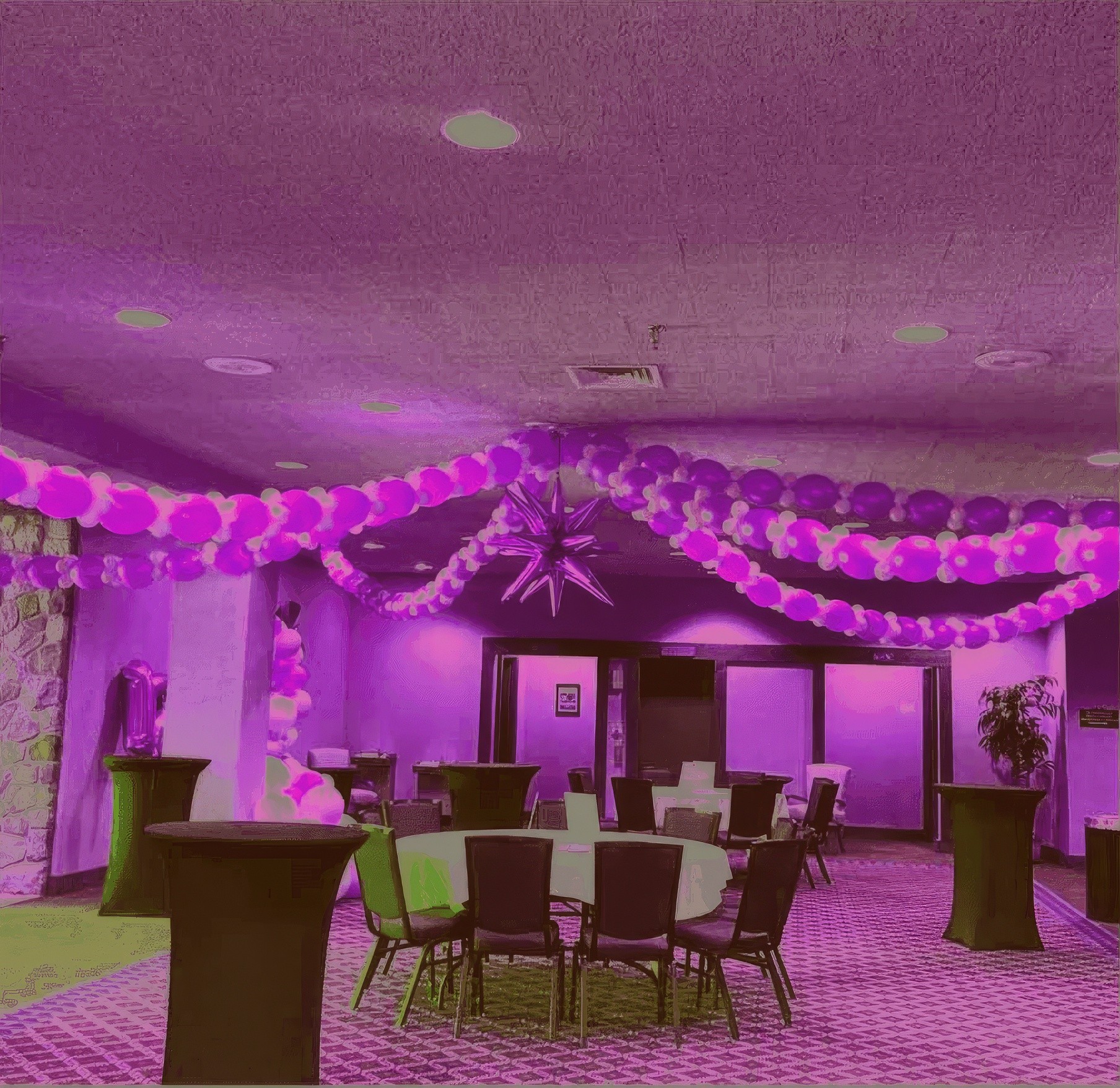 Ceiling decorated with purple and white balloons and hanging streamers for an indoor party setup by Be Bold Balloons