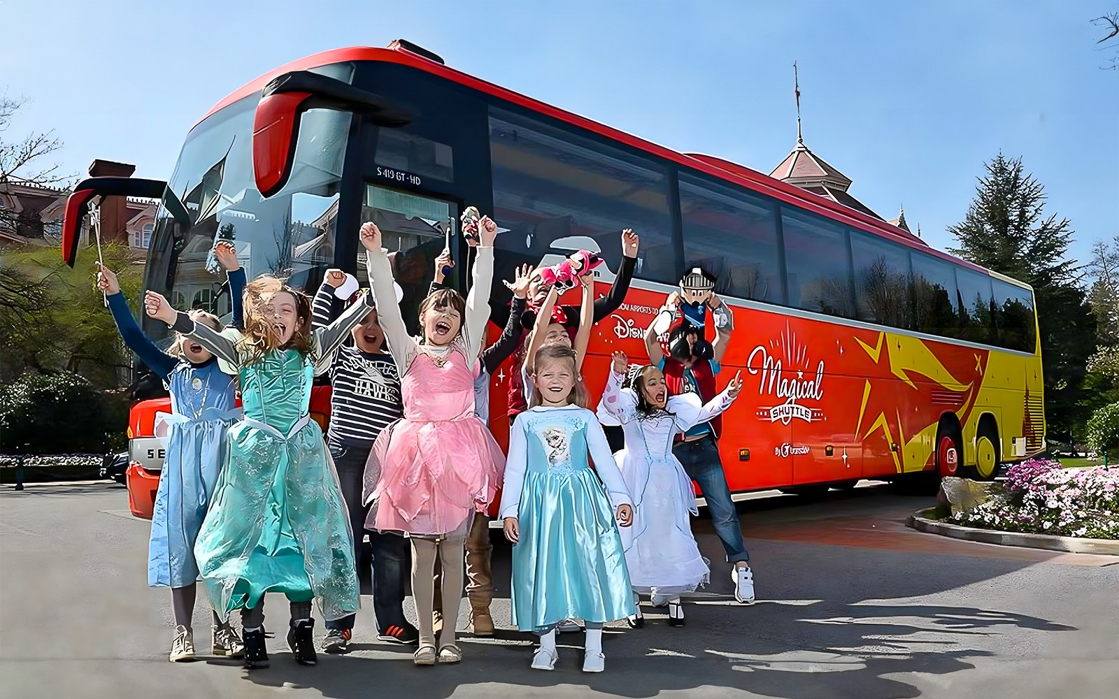Jeunes filles en costumes célébrant près de la Navette Magique à Disneyland Paris.