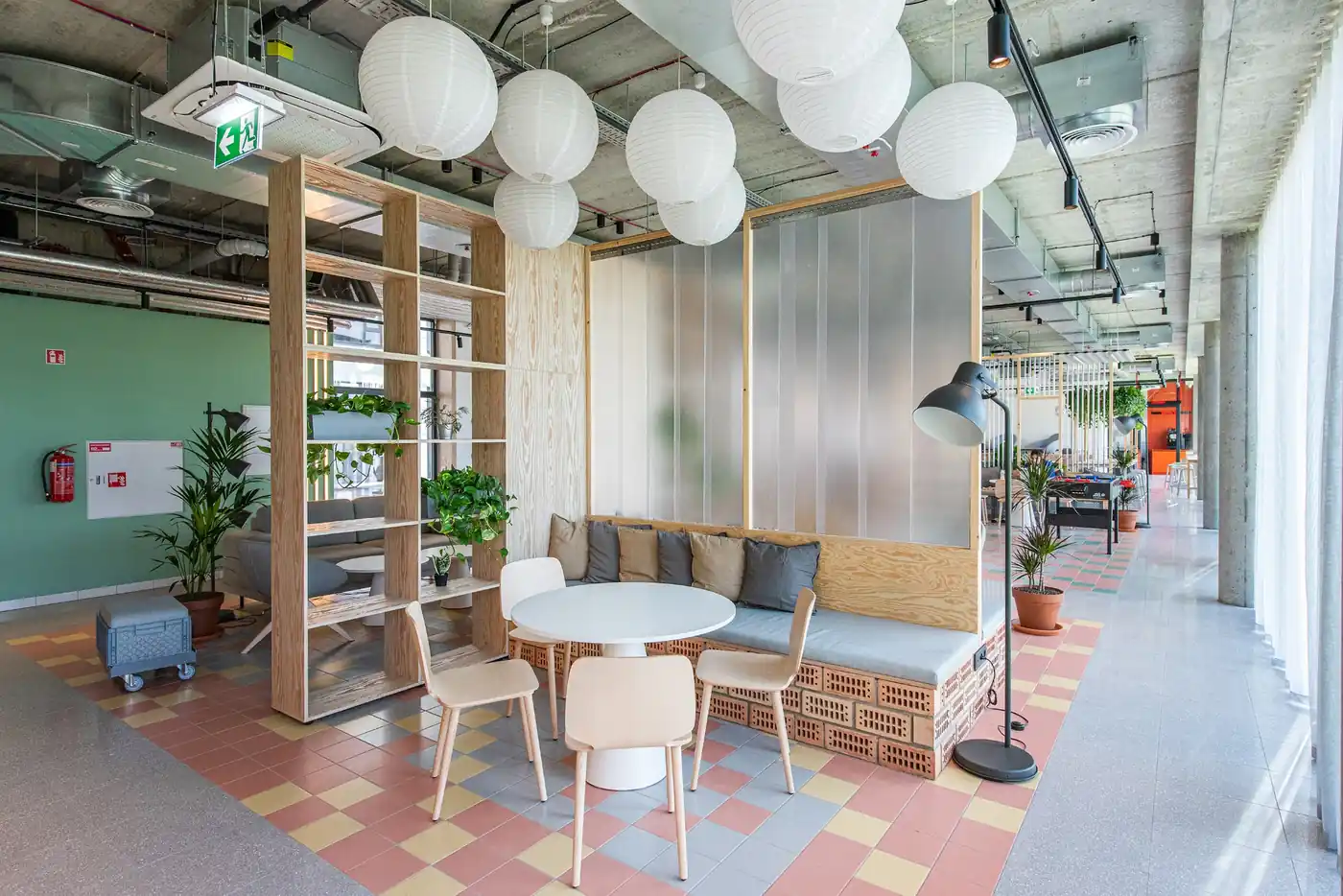 Communal student lounge in Vilnius with sofas, tables, plants and modern shared seating areas.
