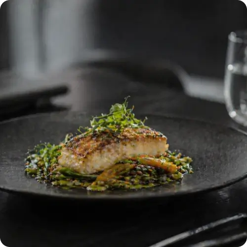 Prato gourmet sofisticado servido em evento premium, com apresentação refinada e acabamento gastronômico de alta cozinha.