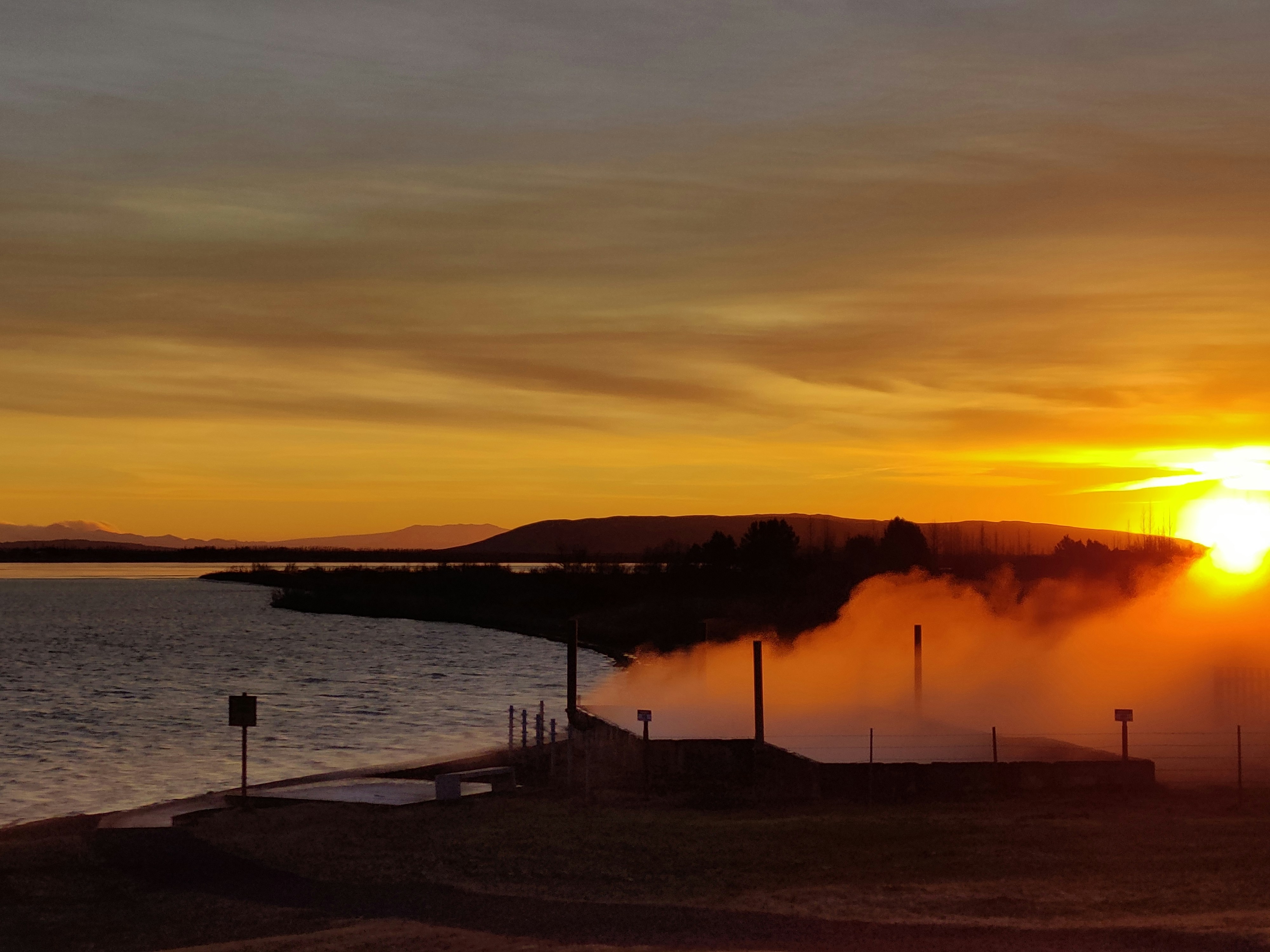 Steam rising from geothermal pools at Laugarvatn Fontana at sunset.