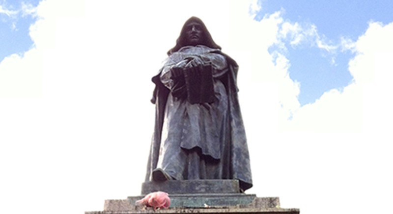 A photo of a statue depicting a person with a book.