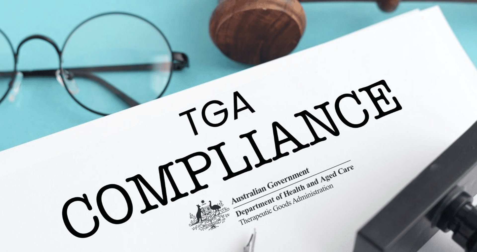 A document titled "TGA Compliance" displaying the Australian Government Department of Health and Aged Care Therapeutic Goods Administration logo, with reading glasses and a wooden gavel on a light blue background.