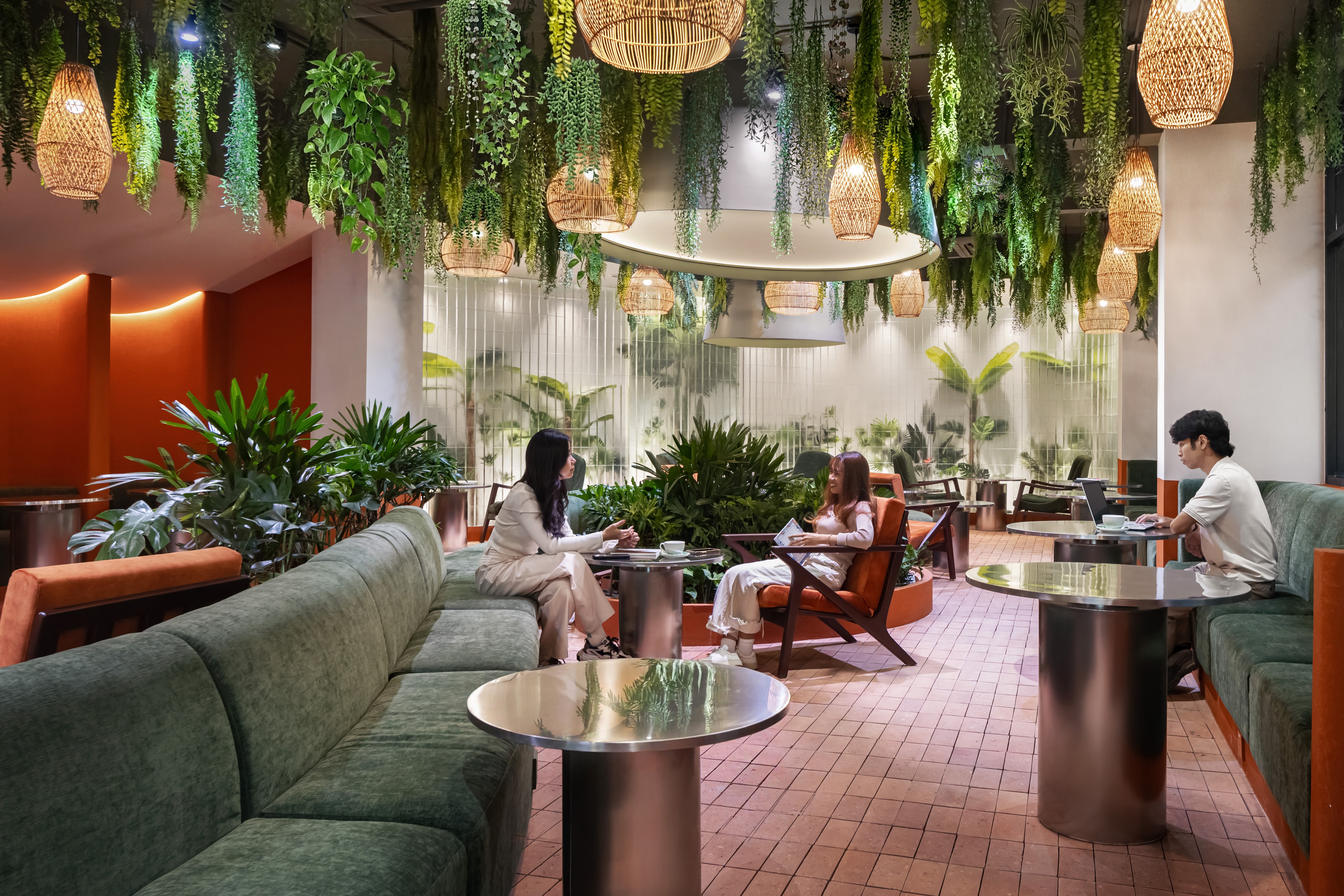 Indoor garden lounge with curved banquette seating, abundant planting and mixed seating types, layout prioritising comfort, operational durability, and extended dwell patterns