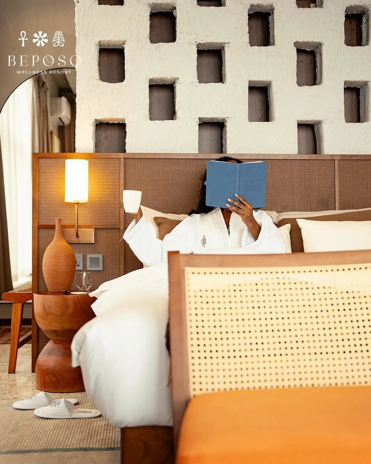 A woman enjoys a peaceful morning reading in a beautifully designed suite on a BookAfrica Wellness experience.