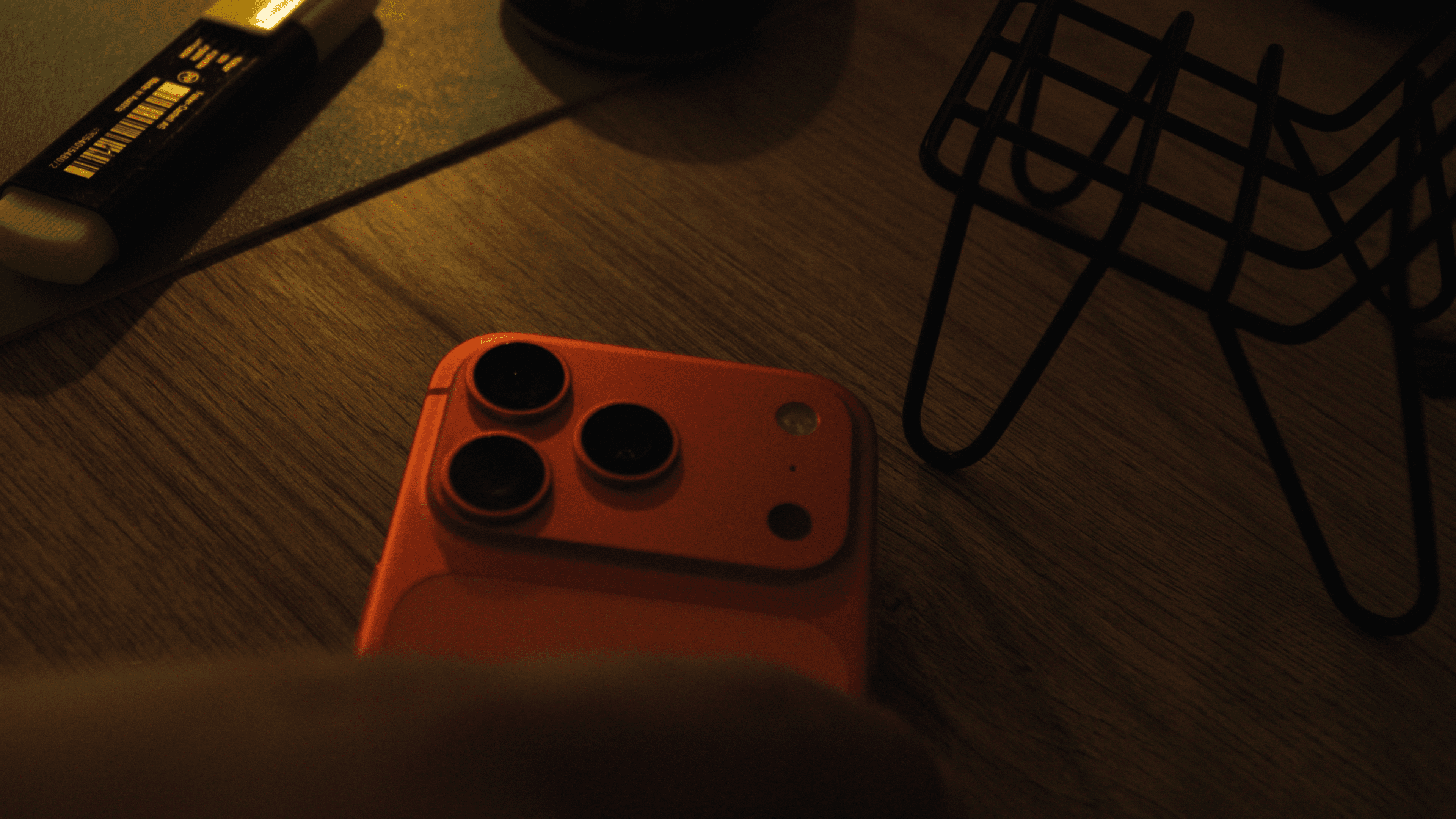 Two focused men in work aprons lean over large blueprints in a dimly lit workshop. A beam of light highlights the papers, creating a dramatic atmosphere.